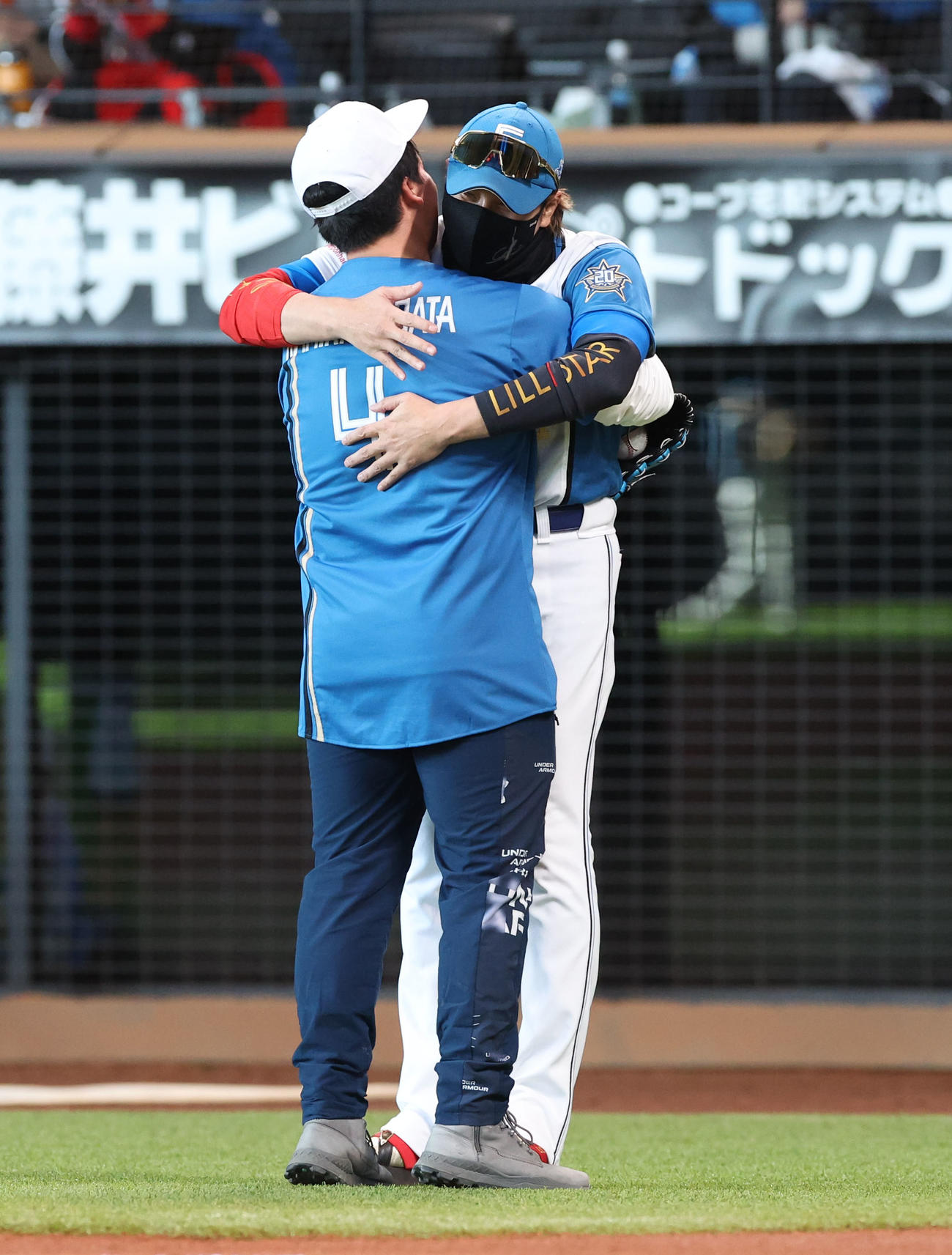 紅白戦の始球式を務めたファンと抱き合う日本ハム新庄監督（撮影・佐藤翔太）