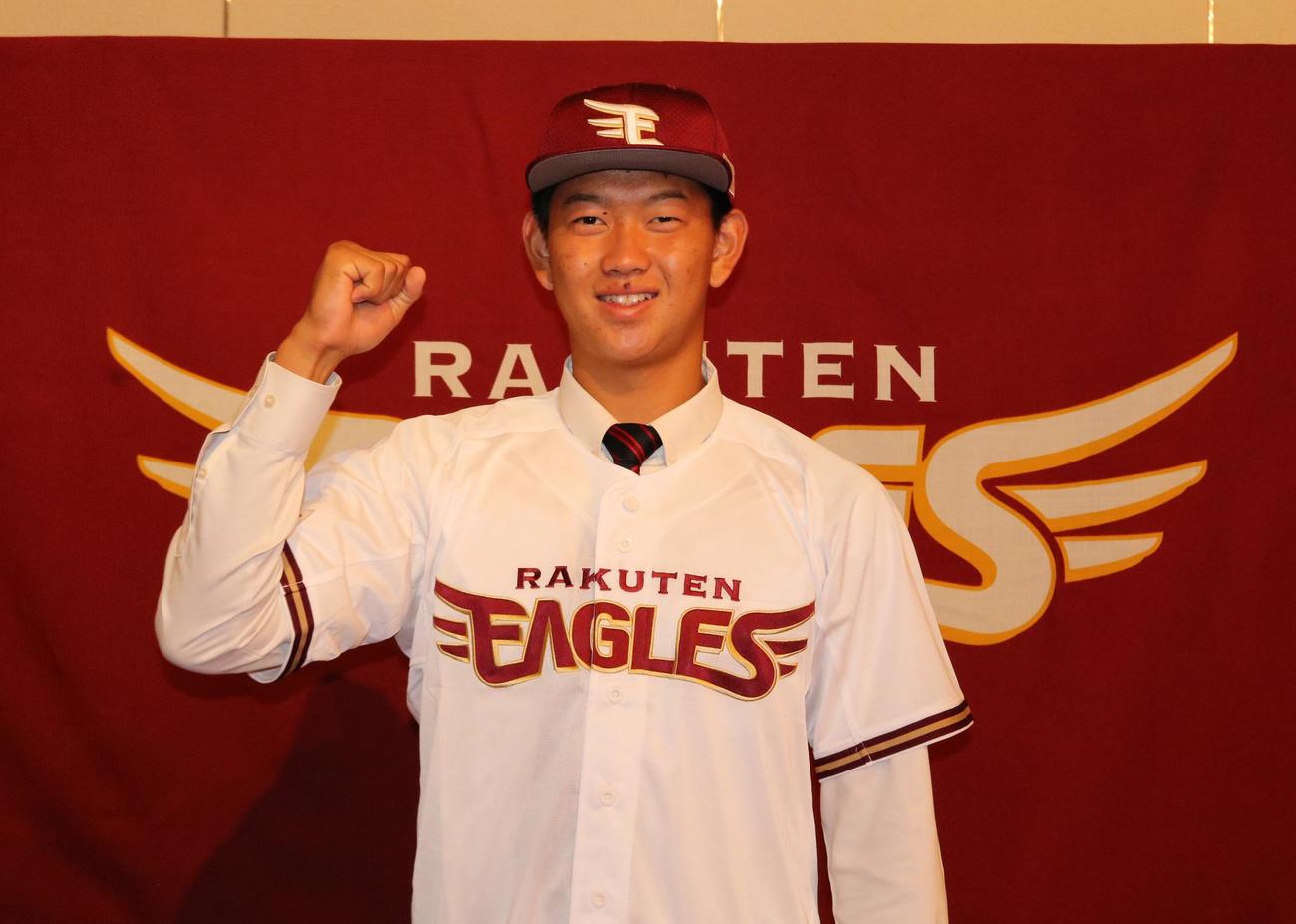 楽天ドラフト2位指名の滝川二・坂井陽翔投手が楽天と入団合意し、ユニホームと帽子を身につけて笑顔でポーズを取る（撮影・林亮佑）＝2023年11月11日、兵庫県内のホテル