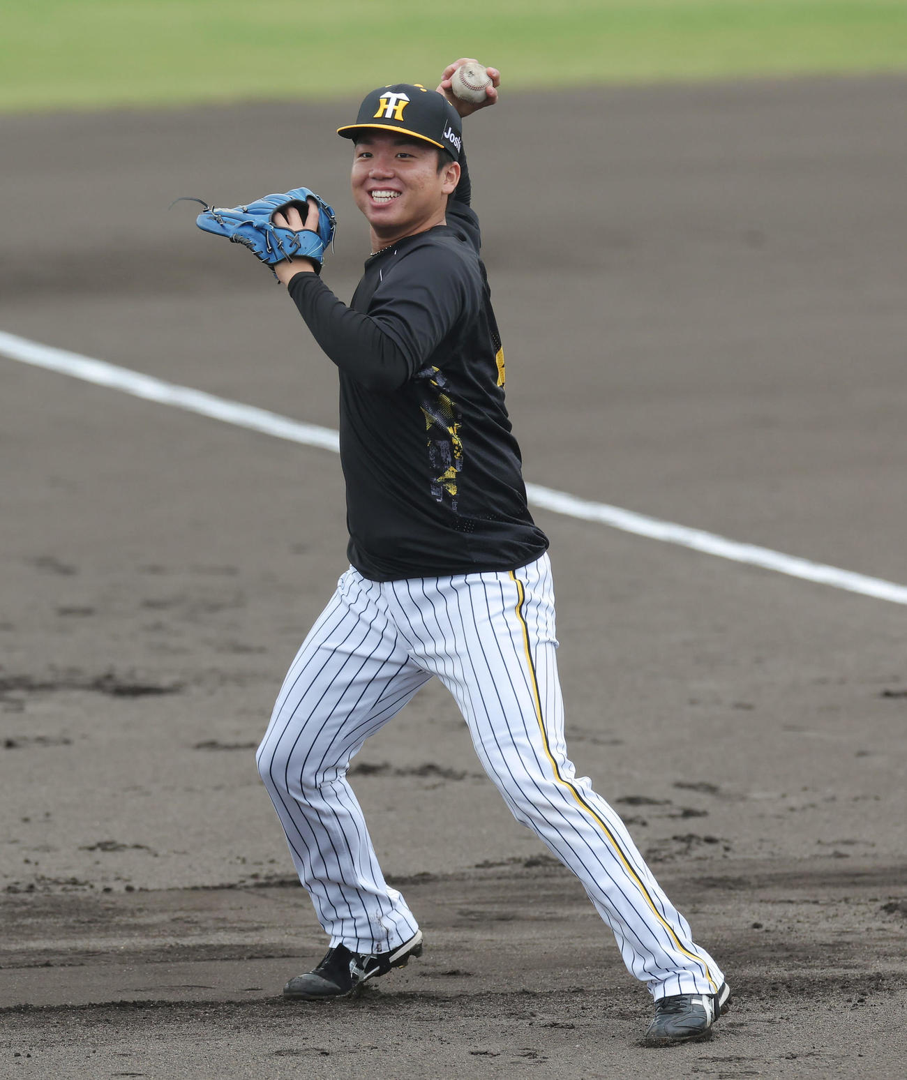 笑顔でノックを受ける阪神村上（撮影・前田充）