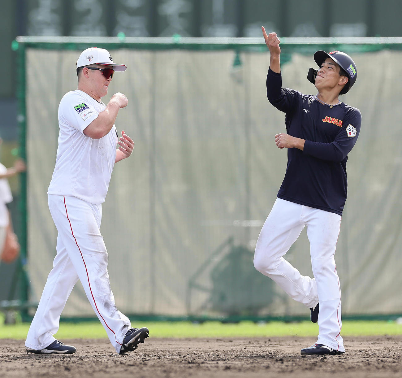 練習中、ジェスチャーをまじえ談笑する牧（左）と門脇（撮影・足立雅史）