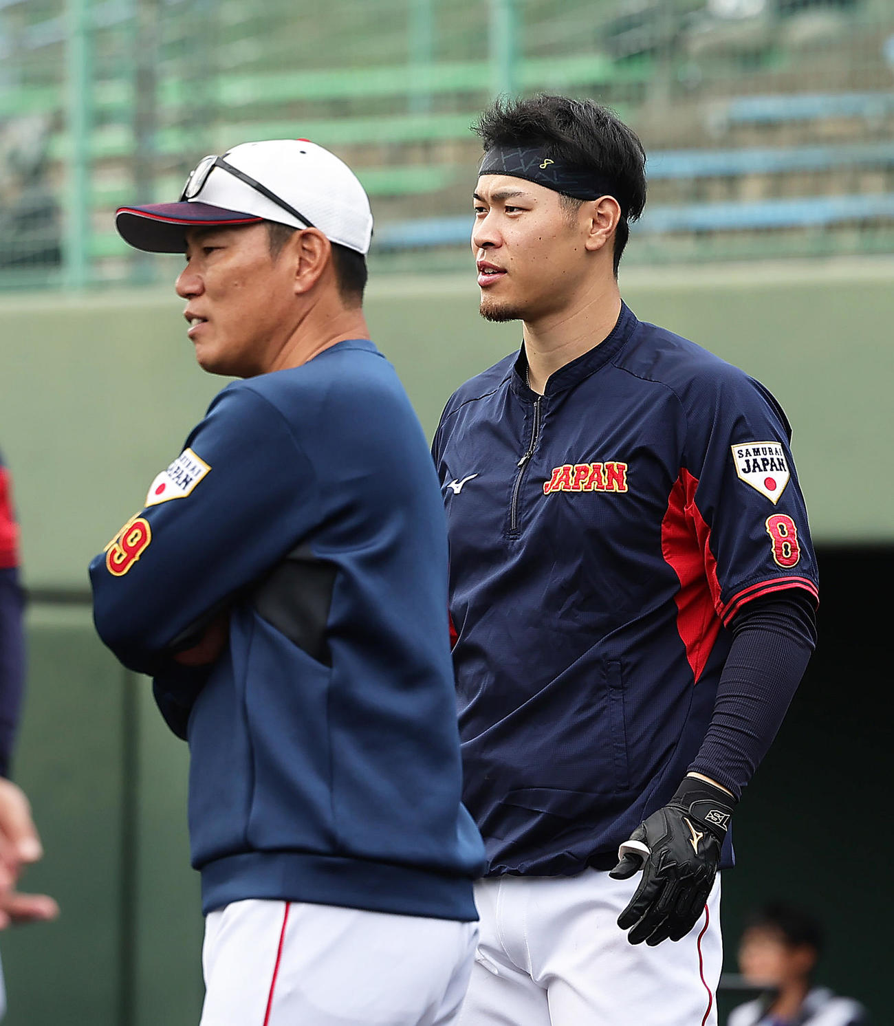 練習中、会話を交わす井端監督（左）と佐藤輝（撮影・足立雅史）