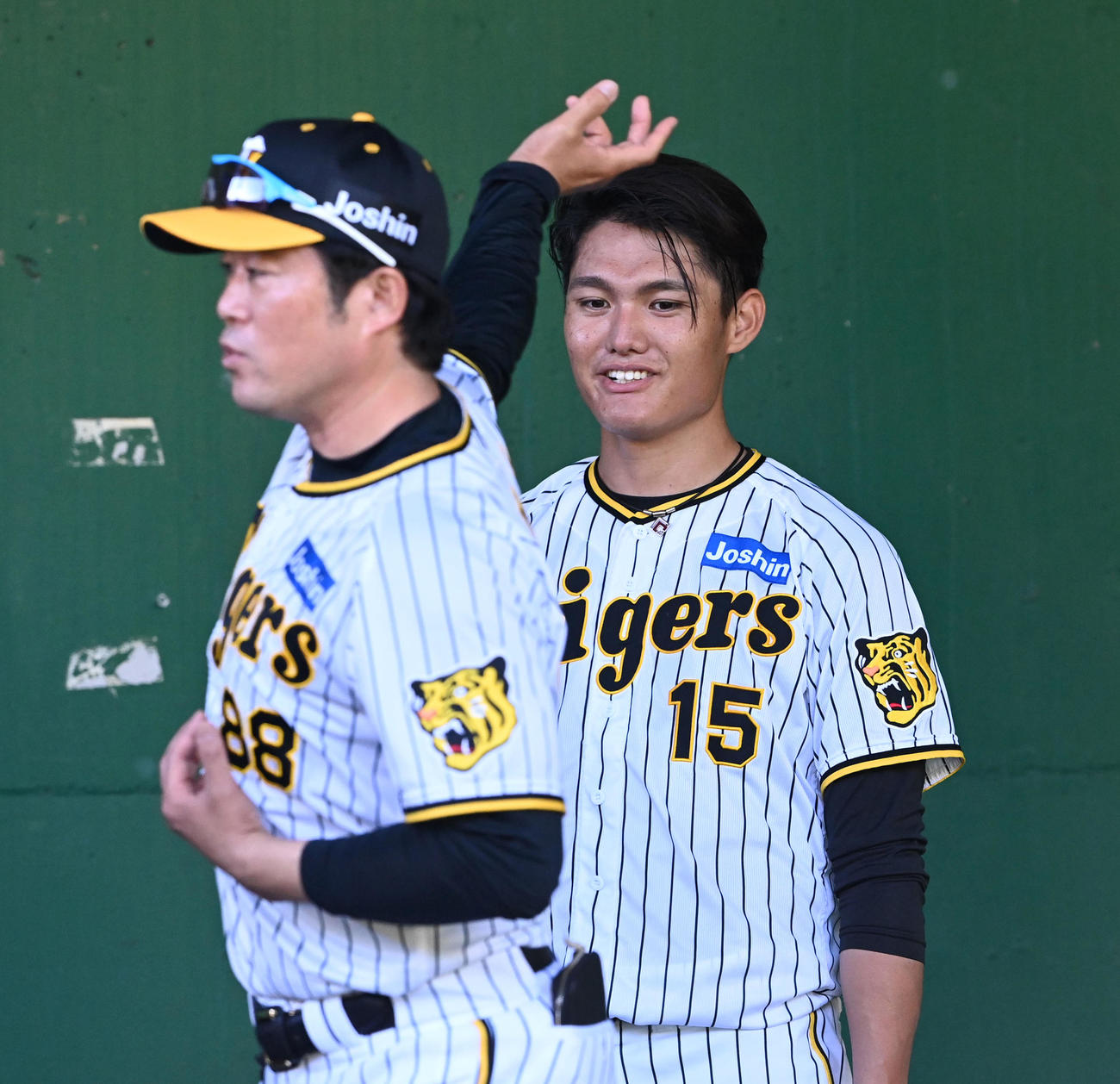 安藤コーチ（左）のアドバイスを笑顔で聞く西純（撮影・前岡正明）