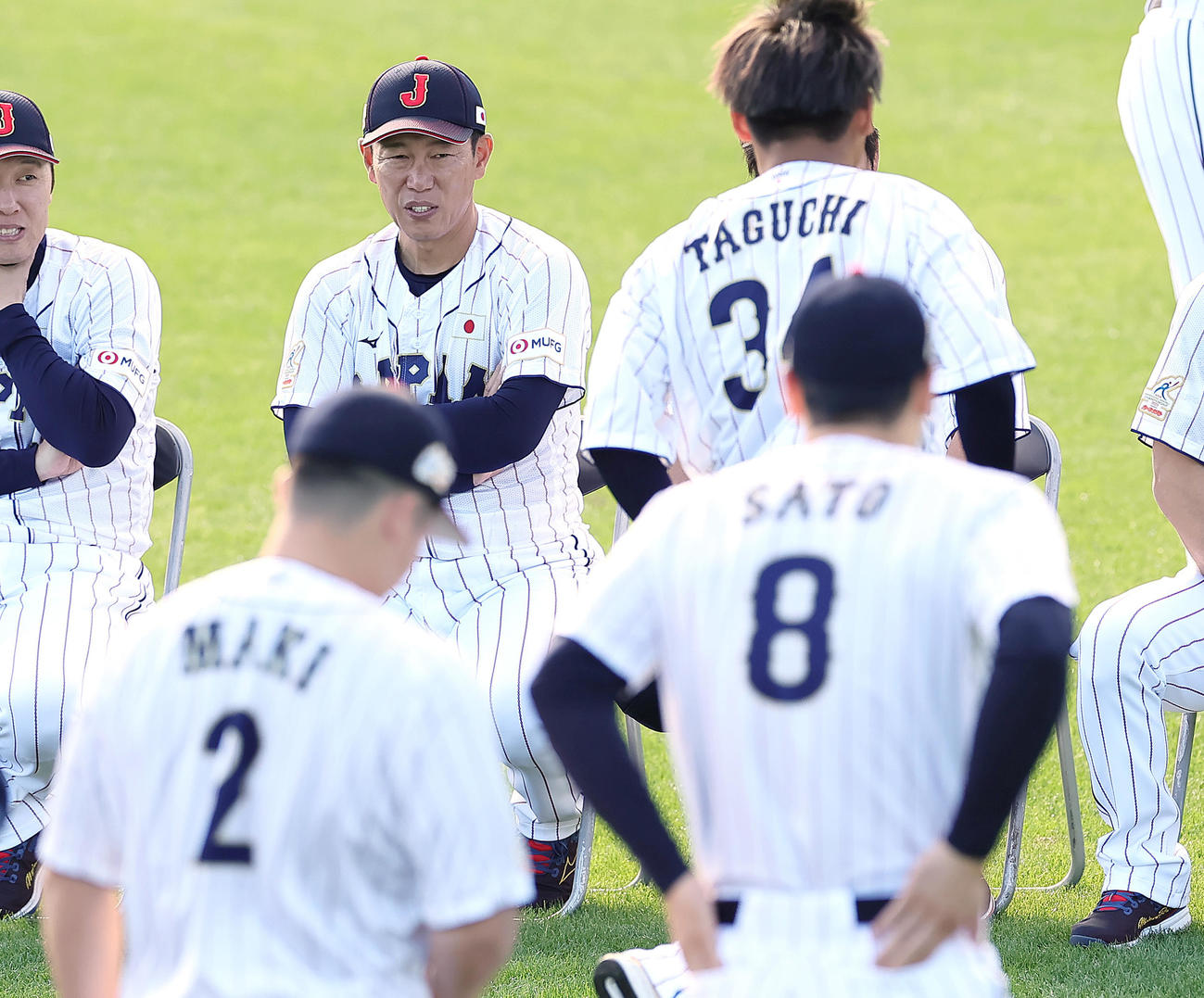 集合写真撮影に臨む牧（手前左）、佐藤輝（同右）らを見つめる井端監督（撮影・足立雅史）