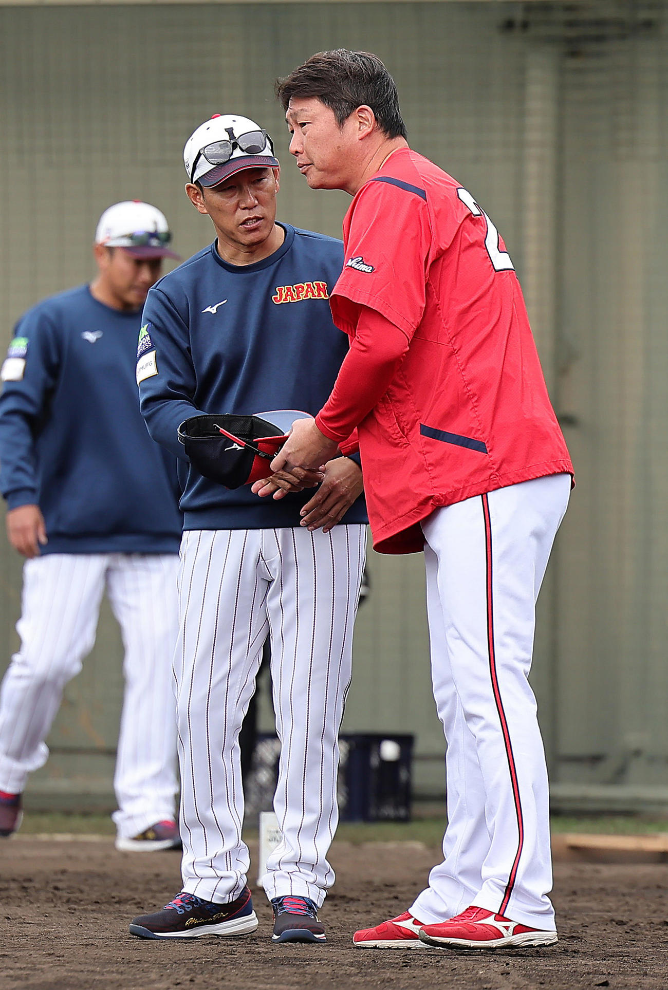 練習中、握手を交わす侍ジャパン井端監督（左）と広島新井監督（撮影・足立雅史）