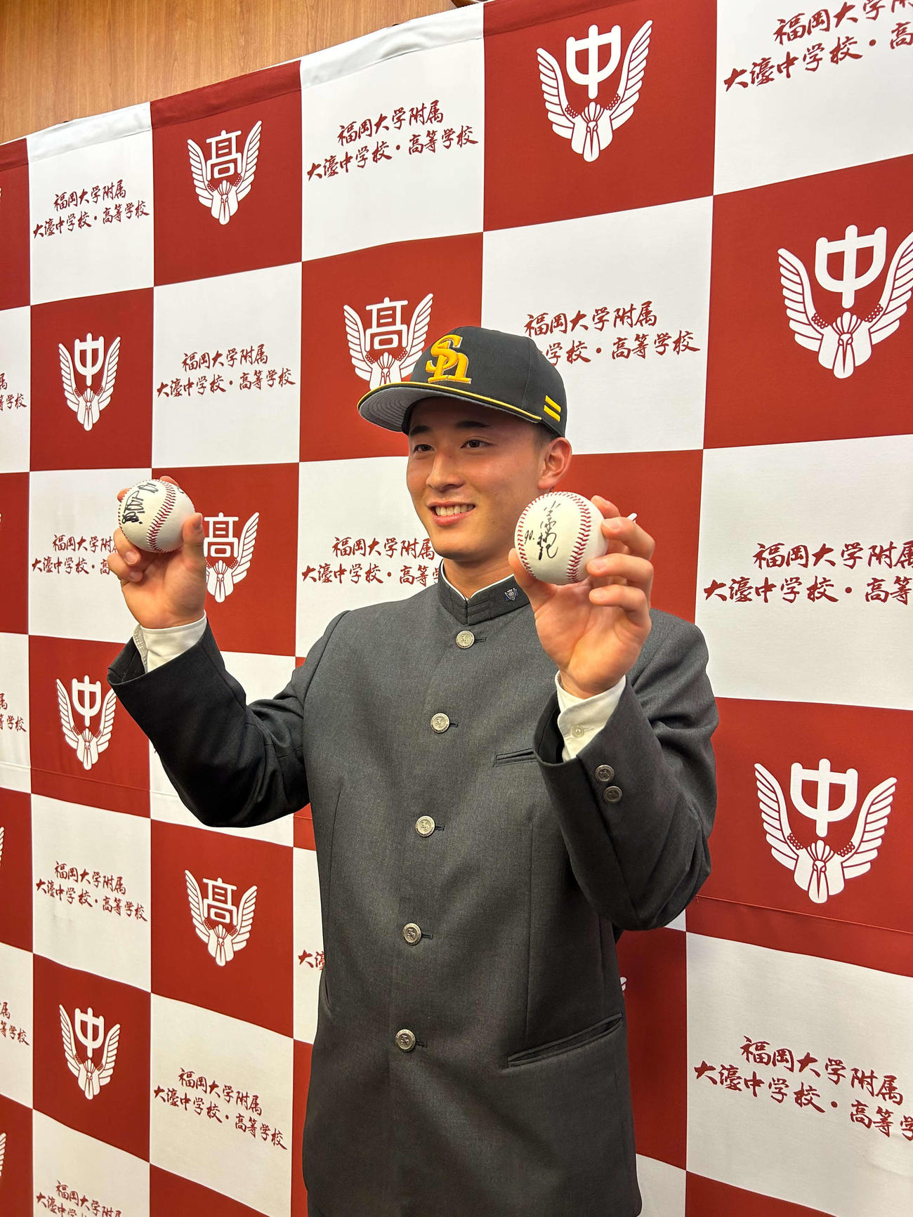 ソフトバンクの指名あいさつ受けた福岡大大濠・藤田悠太郎は、右手にソフトバンク王球団会長のサインボール、左手には小久保監督のサインボールを手に笑顔を見せる（2023年11月1日撮影）