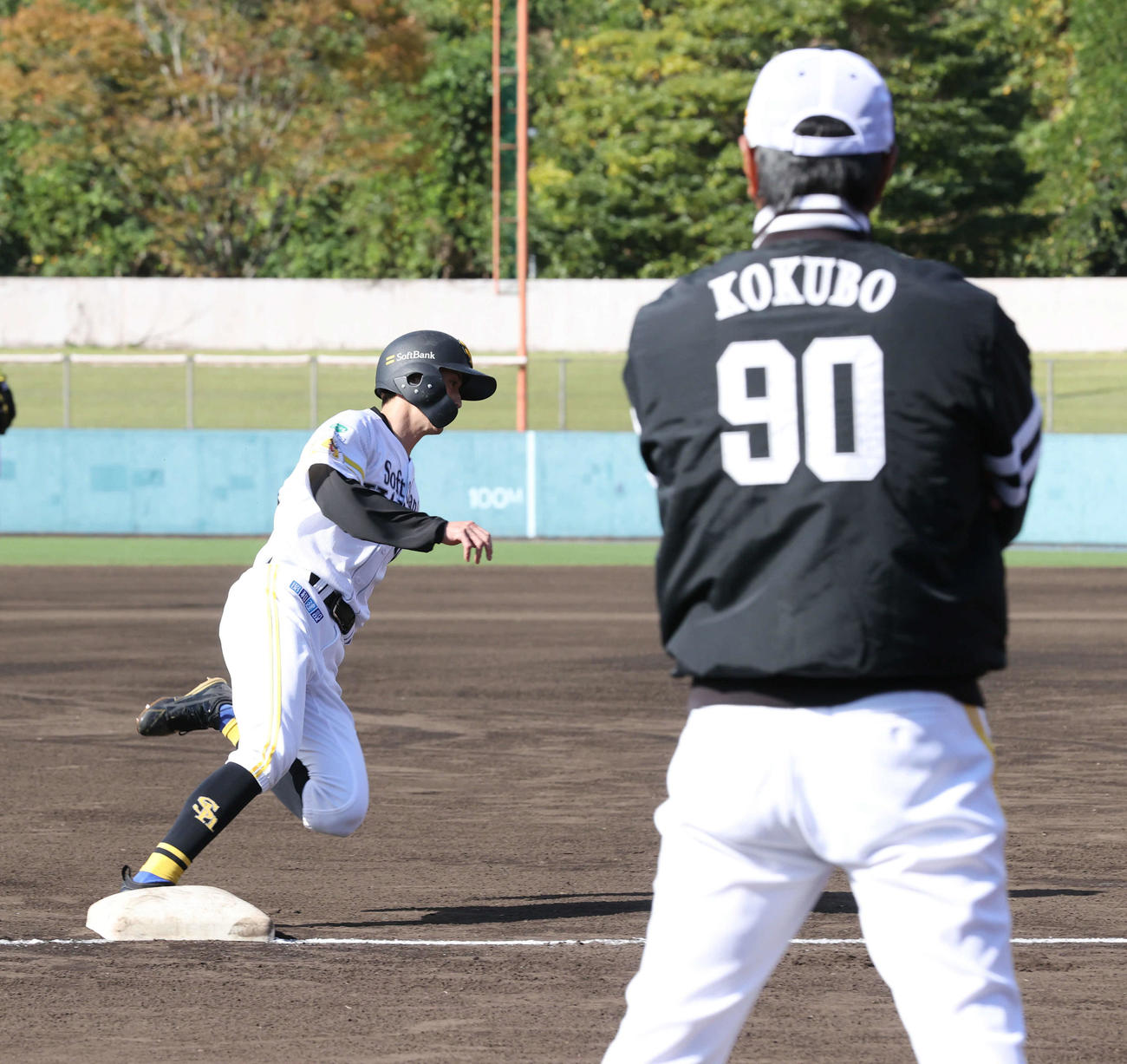 走塁練習で軽快にベースランニングを行う周東。手前は小久保監督（撮影・梅根麻紀）