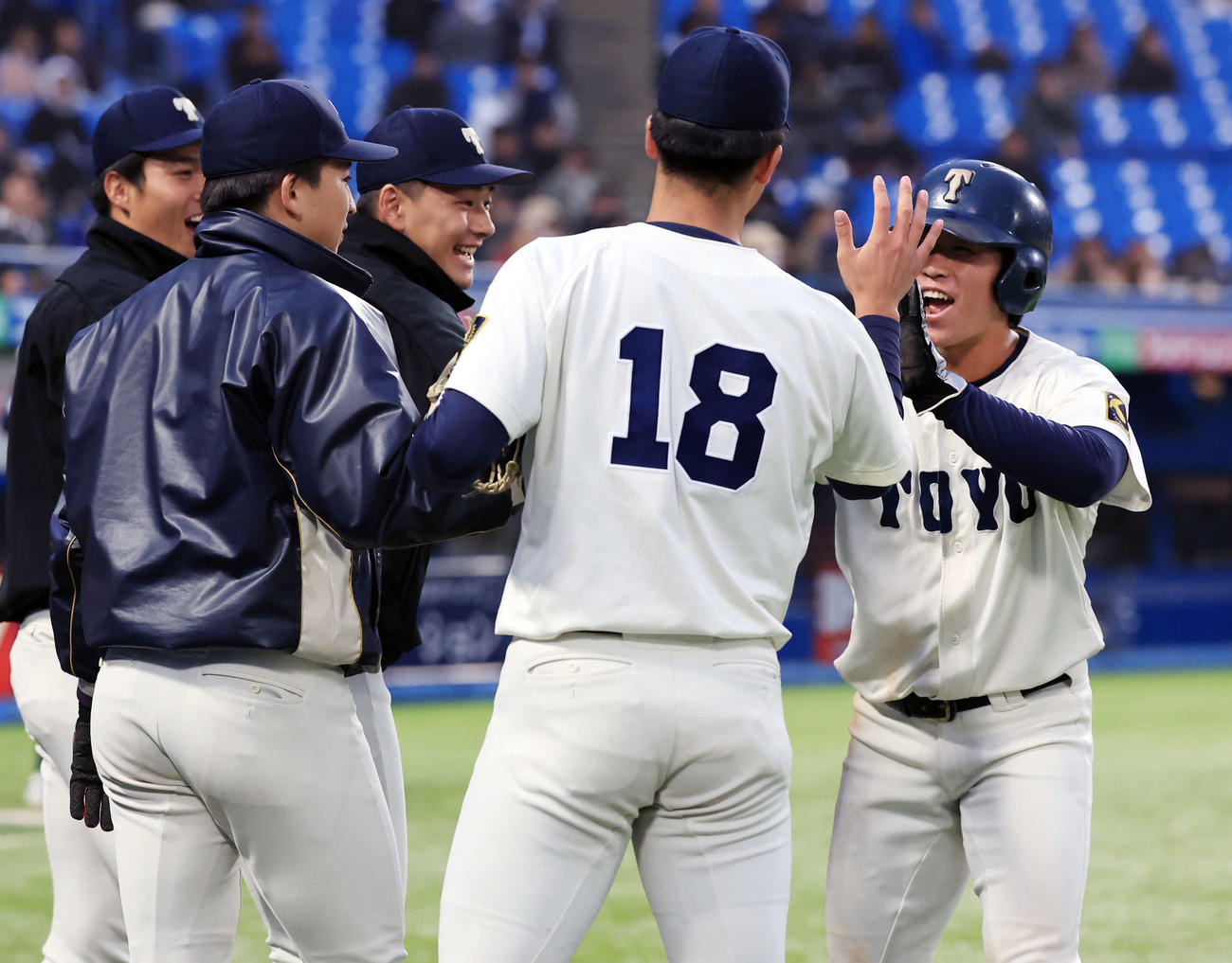 駒大対東洋大　2回裏東洋大1死一、三塁、山田の適時二塁打で生還した石上泰（右）は笑顔でナインとハイタッチ（撮影・浅見桂子）