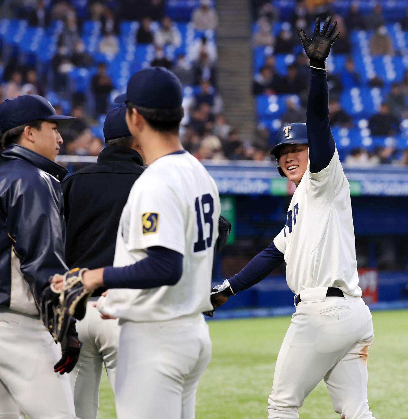 駒大対東洋大　2回裏東洋大1死一、三塁、山田の適時二塁打で生還した石上（右）は笑顔でスタンドに手を上げる（撮影・浅見桂子）