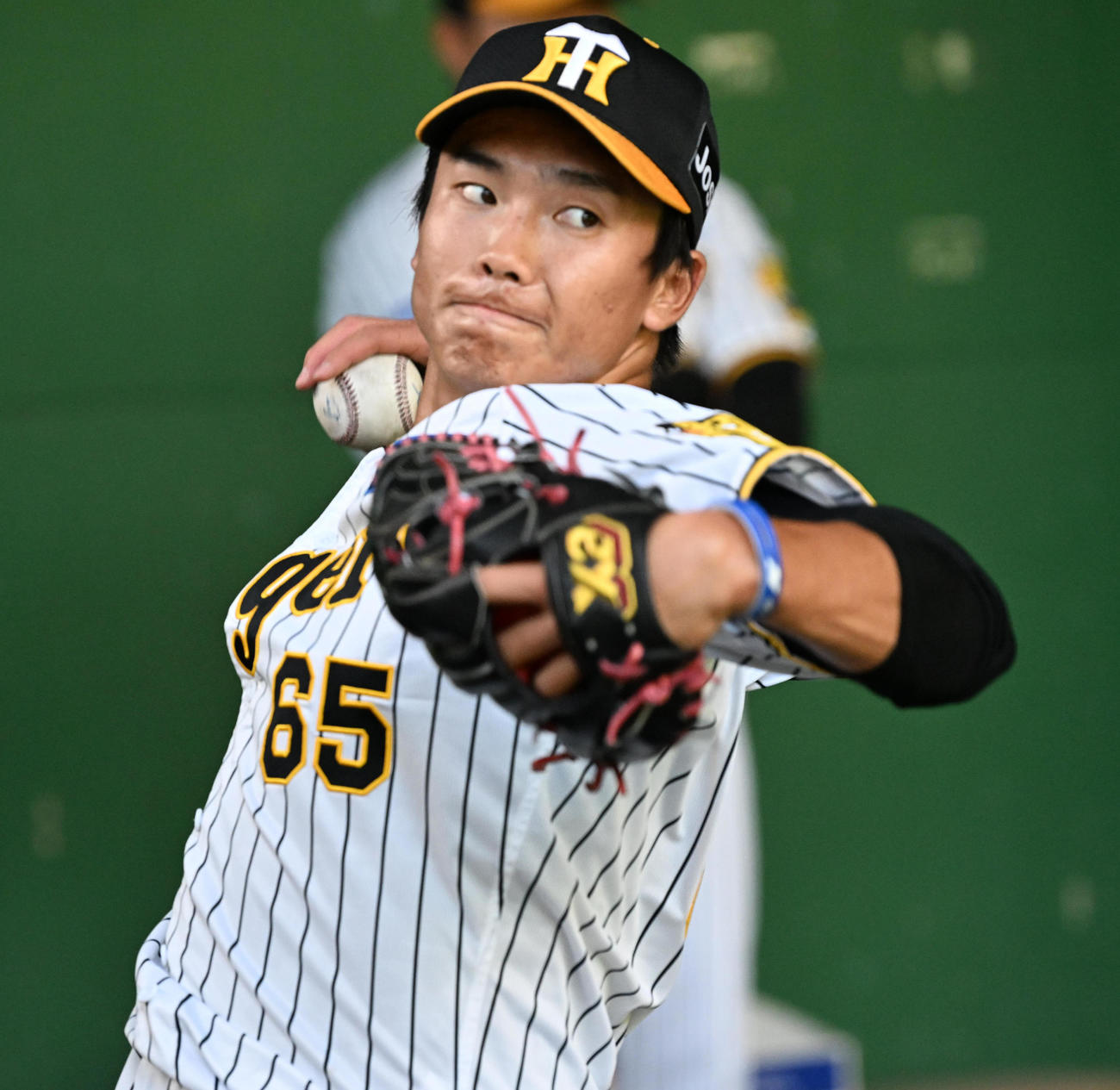 ブルペンで投球練習を行う湯浅（撮影・前岡正明）