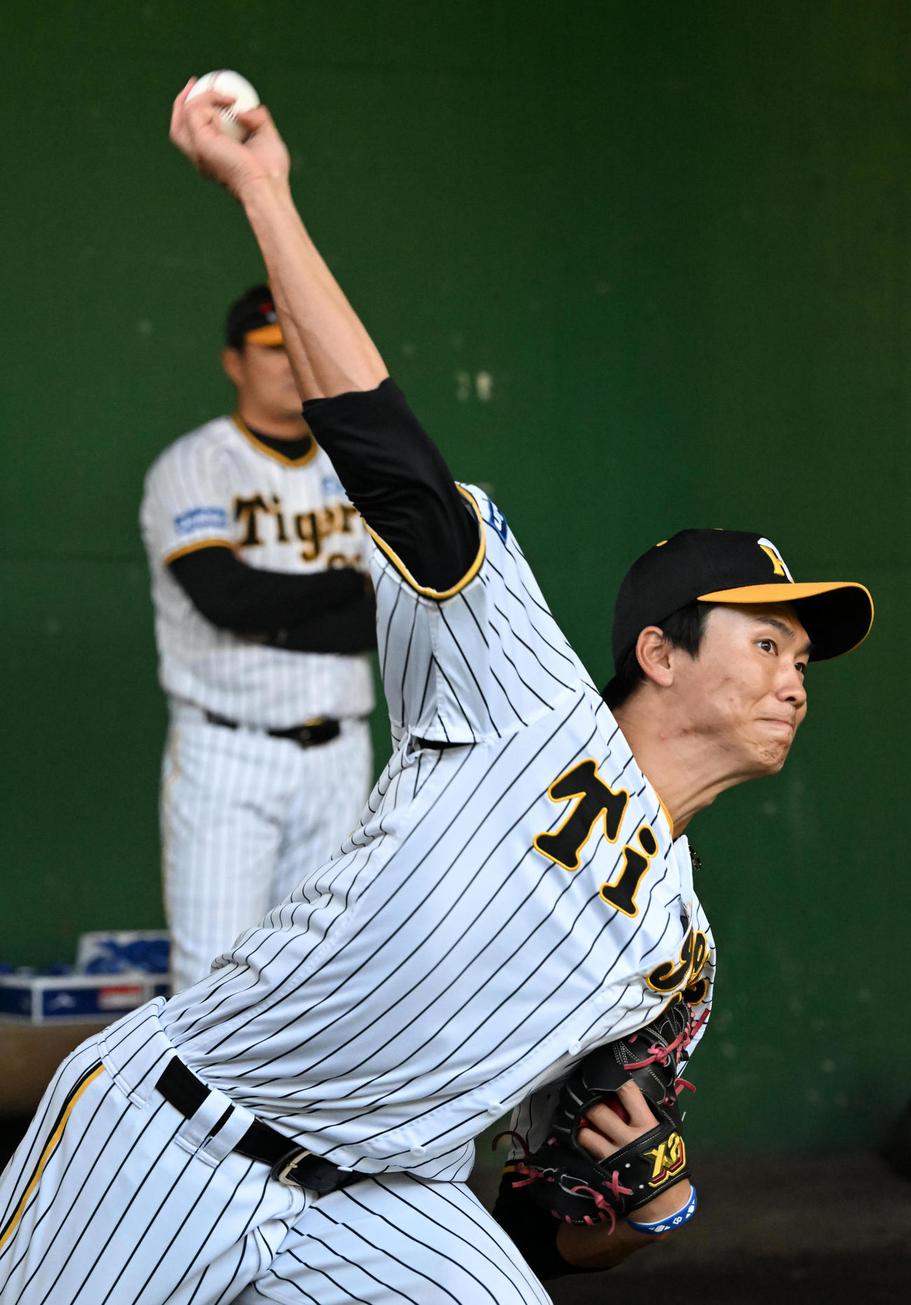 ブルペンで投球練習を行う湯浅（撮影・前岡正明）