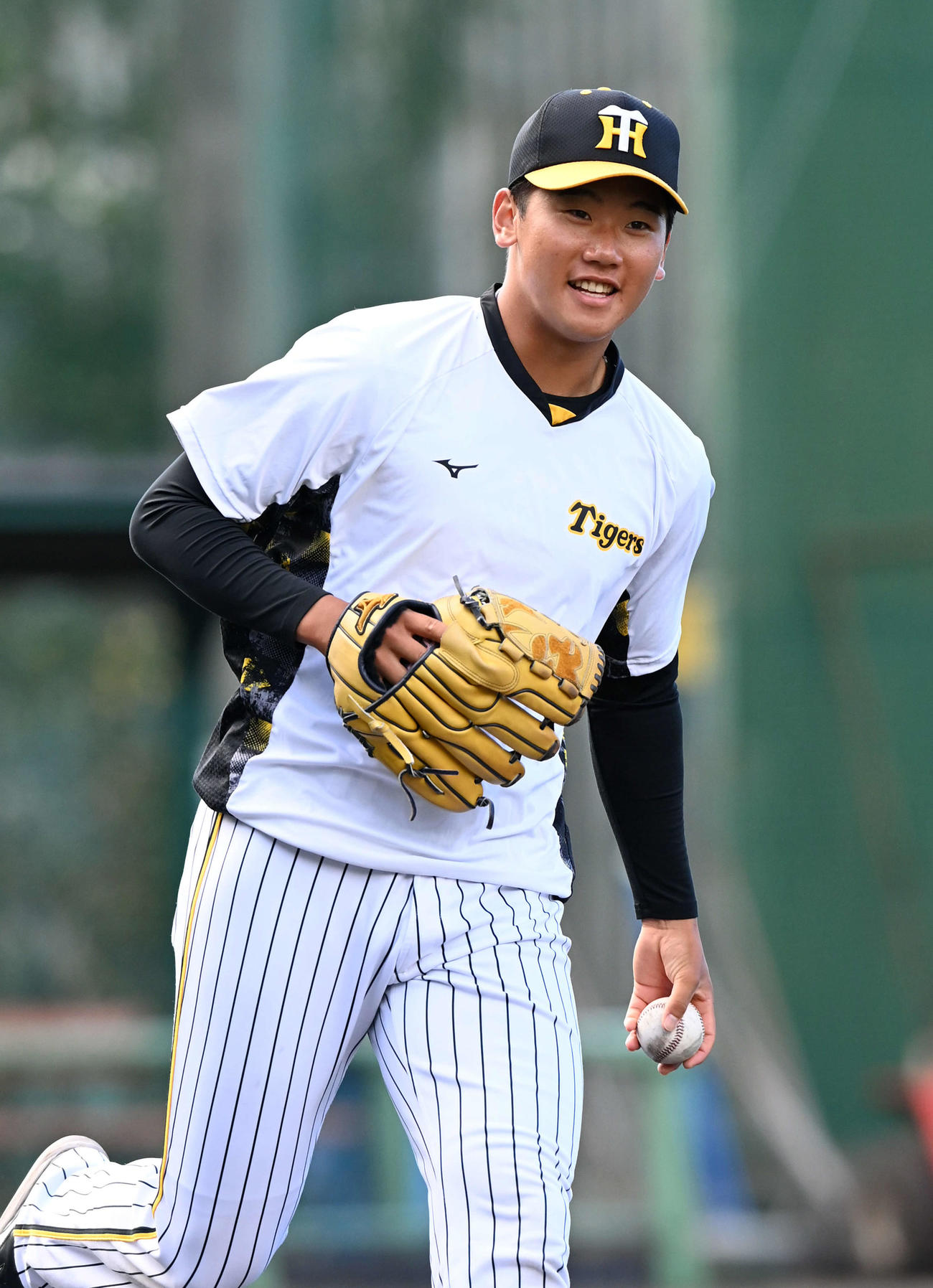 投内連係で笑顔を見せる阪神門別（撮影・前岡正明）