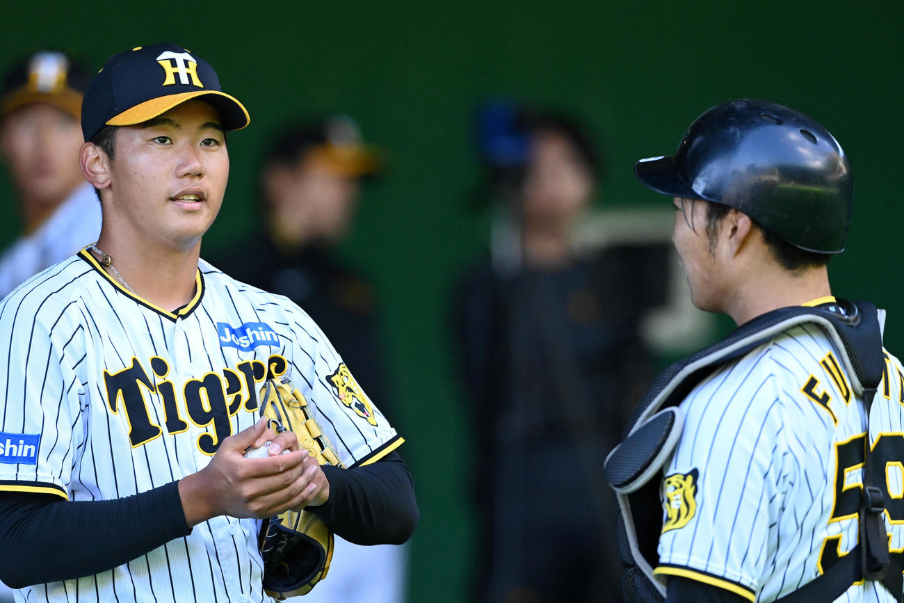 投球練習後、藤田健斗（右）と話す門別啓人（撮影・前岡正明）