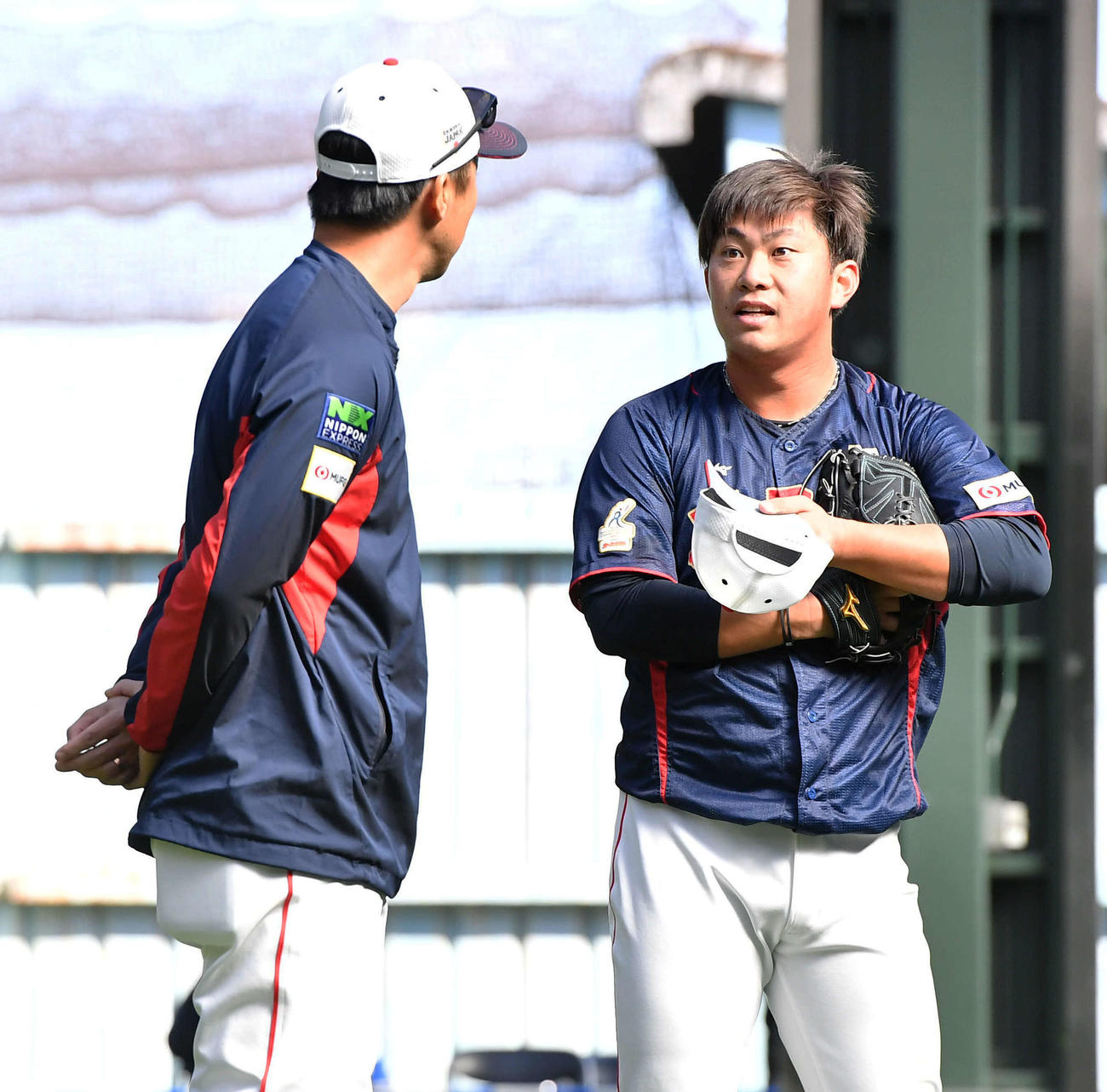 ブルペンでの投球を終え、吉見コーチ（左）と話す桐敷（撮影・岩下翔太）