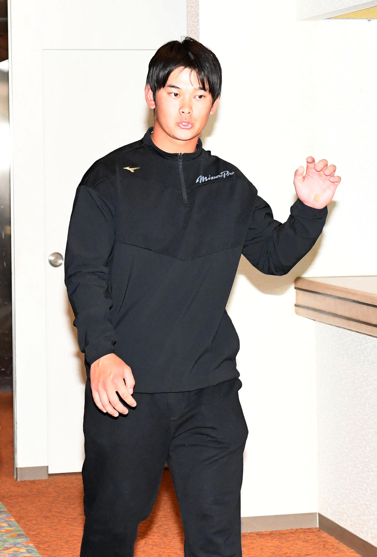 支配下登録が決まり、囲み取材に向かう野口（撮影・前岡正明）