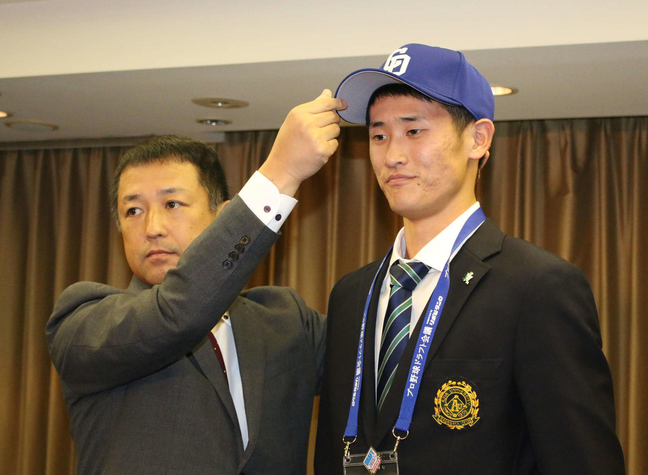 都内のホテルで中日と仮契約を結んだドラフト1位の亜大・草加勝投手（左は正津英志スカウト）（撮影・木下大輔）