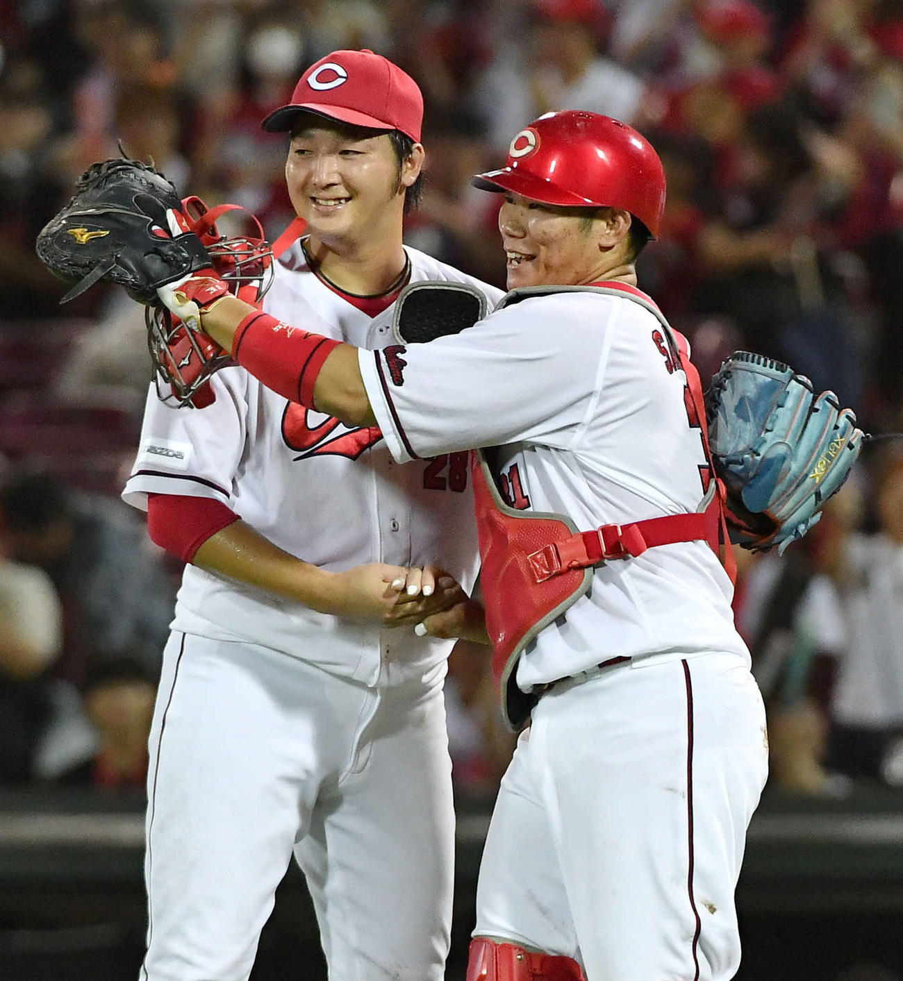 8月、阪神戦で10勝目を挙げ坂倉（右）と笑顔で握手を交わす広島床田