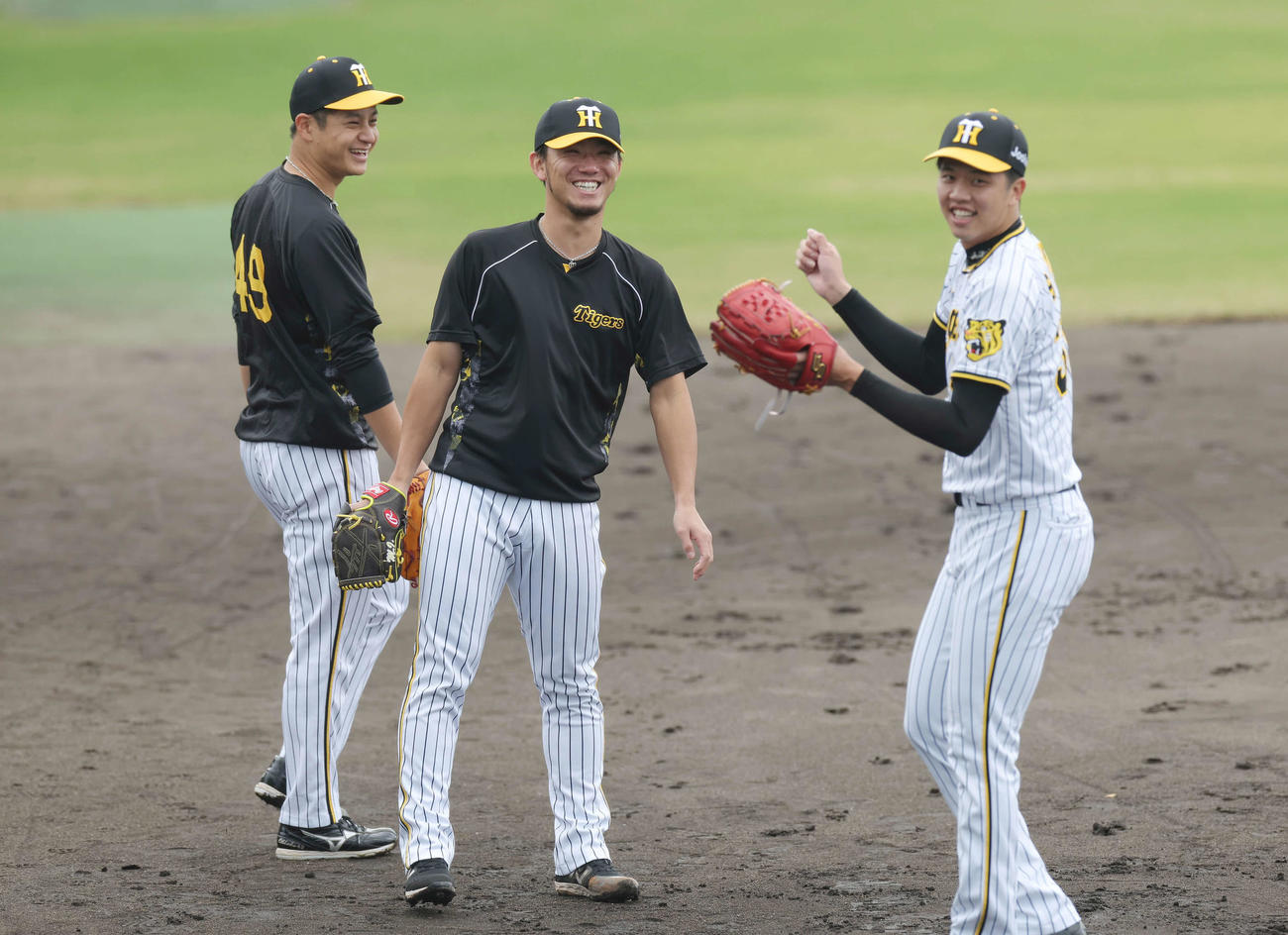 11日、ノックで笑顔を見せる、左から阪神大竹、伊藤将、才木