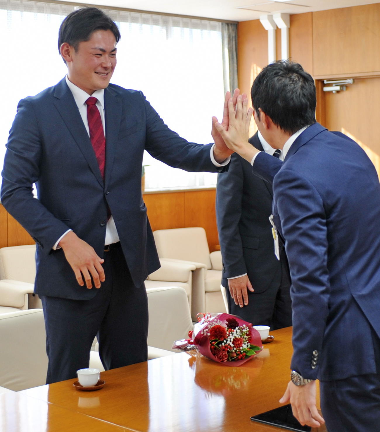 赤塚（左）と手の大きさを比較する草地市長　