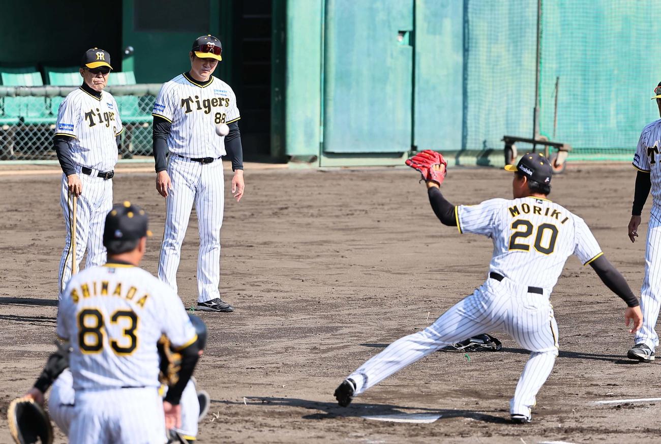 岡田監督（左）は投内連携プレーの練習を見守る（撮影・上田博志）