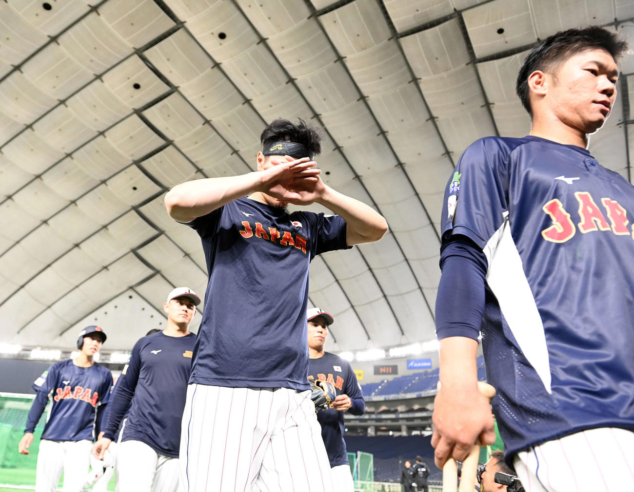 練習を終え、顔を覆って引き揚げる佐藤輝（撮影・たえ見朱実）