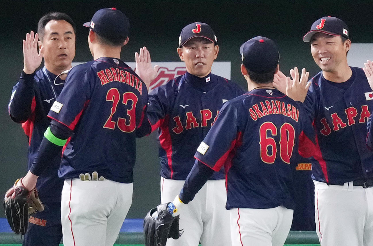 台湾に勝利し、森下（左から2人目）らをタッチで迎える井端監督（中央）（撮影・菅敏）