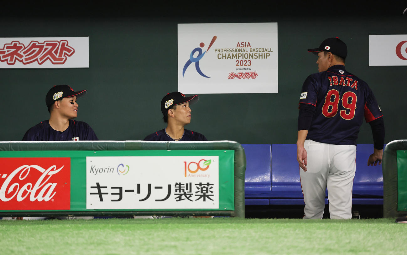 日本対台湾　ヒーローインタビューを待つ森下（左）と門脇（中央）に声をかける井端監督（撮影・足立雅史）