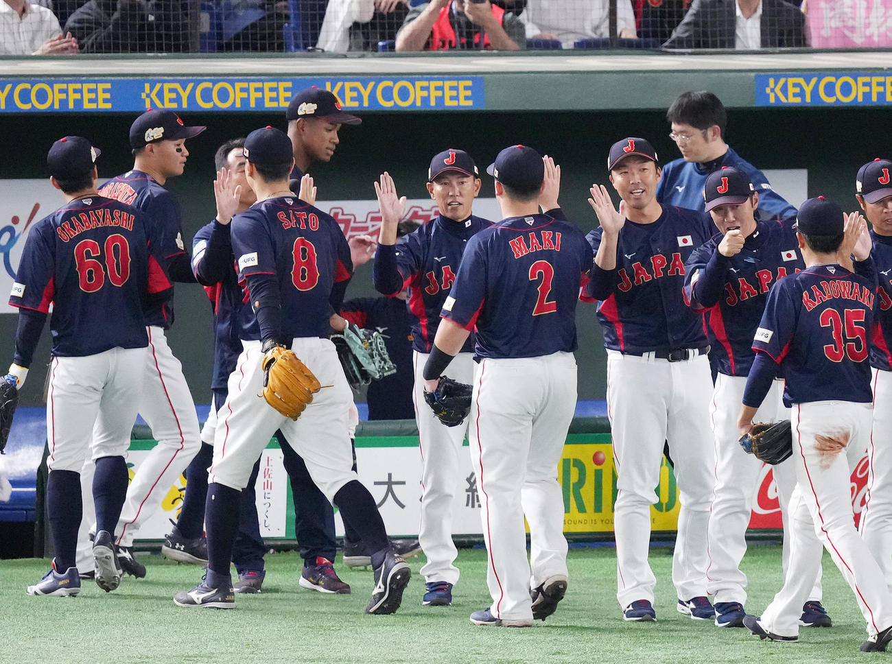 日本対台湾　台湾に勝利した井端監督（中央）は選手とタッチを交わす（撮影・菅敏）
