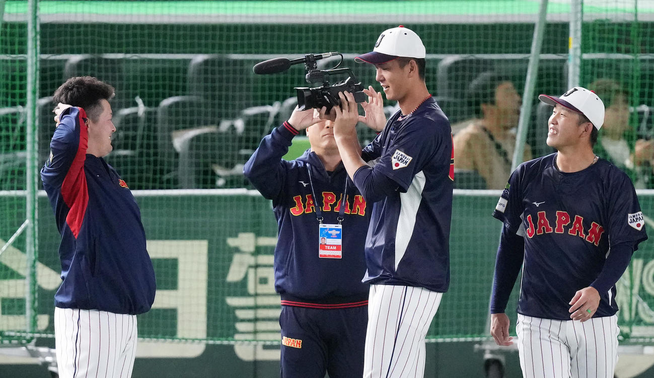 日本対韓国　試合前の練習中に牧（左）を動画撮影する秋広（中央）。右は小園（撮影・菅敏）