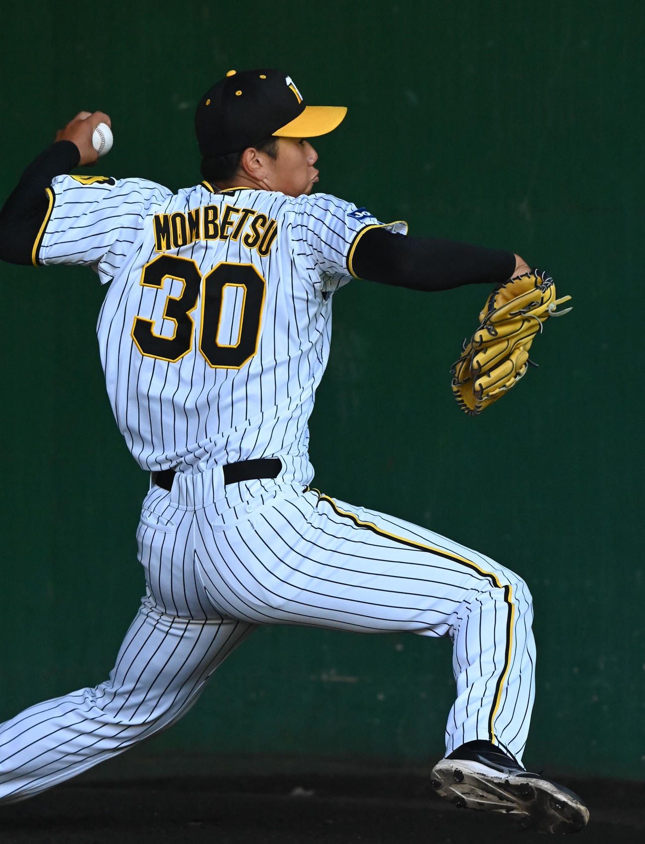 ブルペンで投球練習を行う門別（撮影・前岡正明）