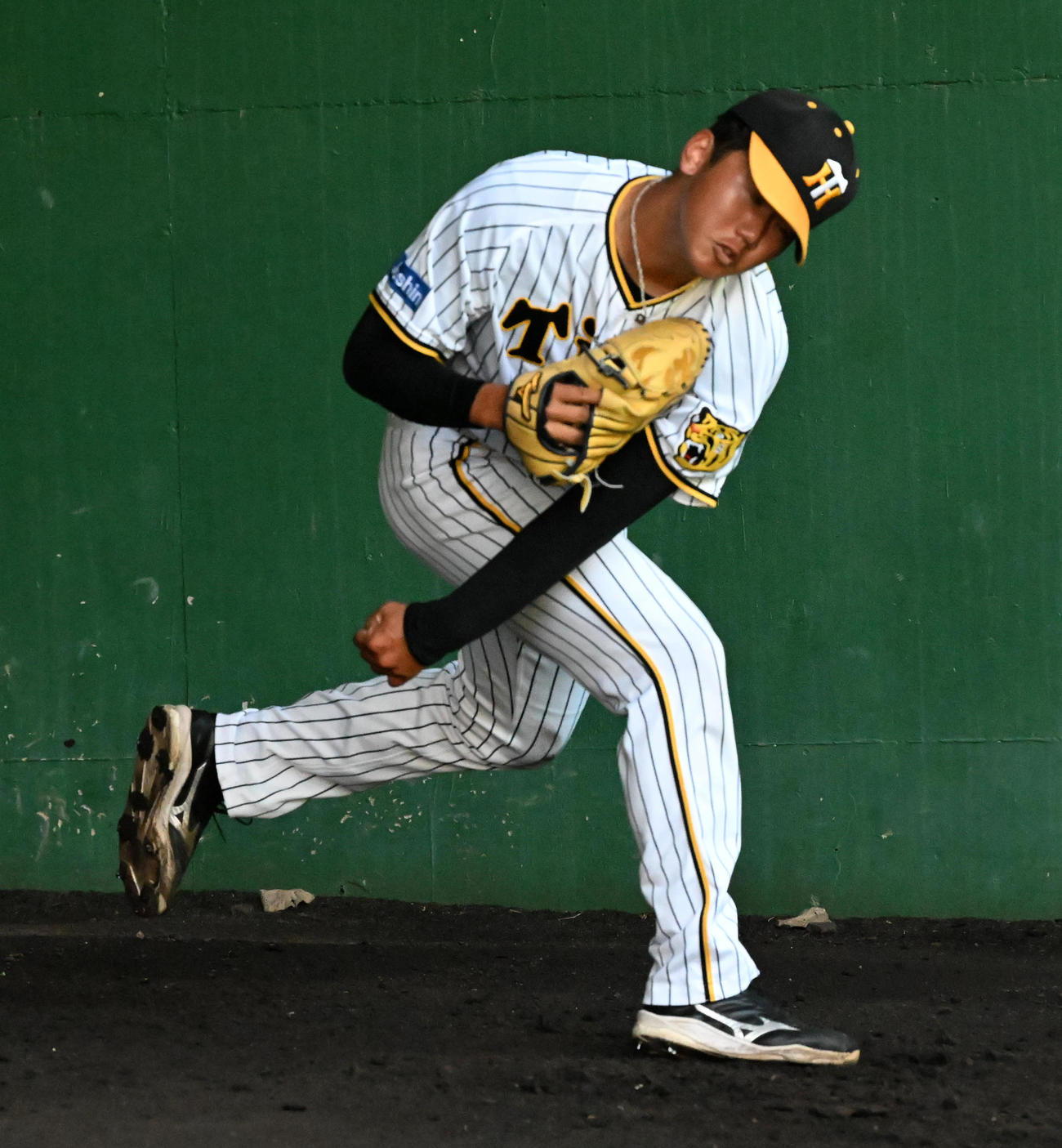 ブルペンで投球練習を行う門別（撮影・前岡正明）