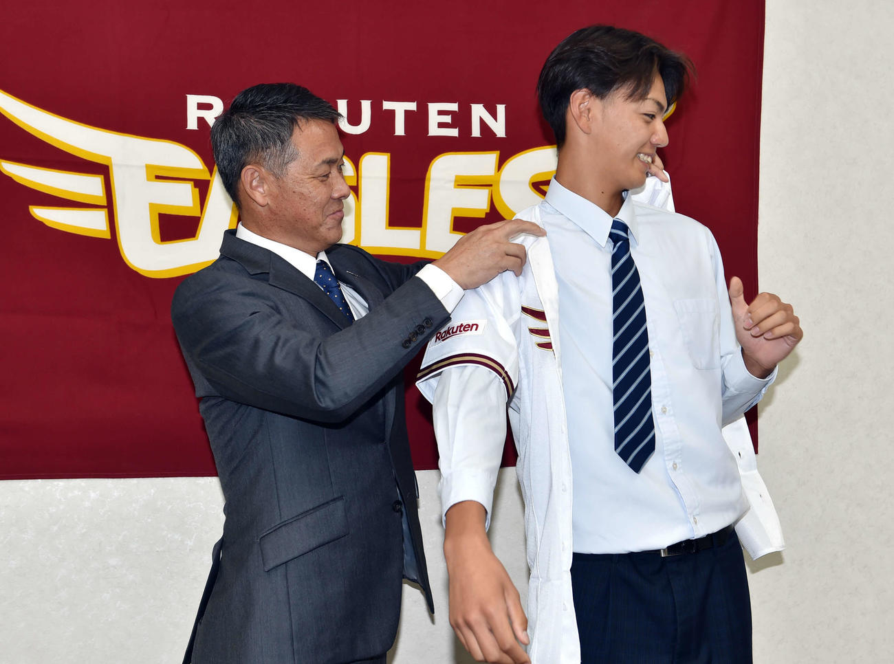 益田スカウト（左）からユニホームを着させてもらう大内