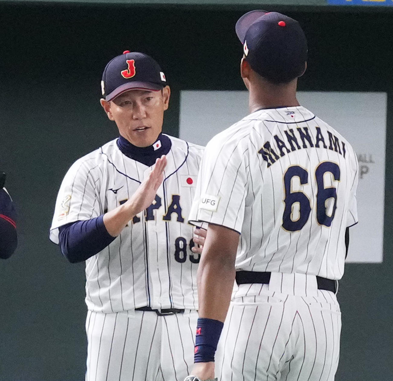 韓国に勝利し、万波（右）をタッチで迎える井端監督（撮影・菅敏）