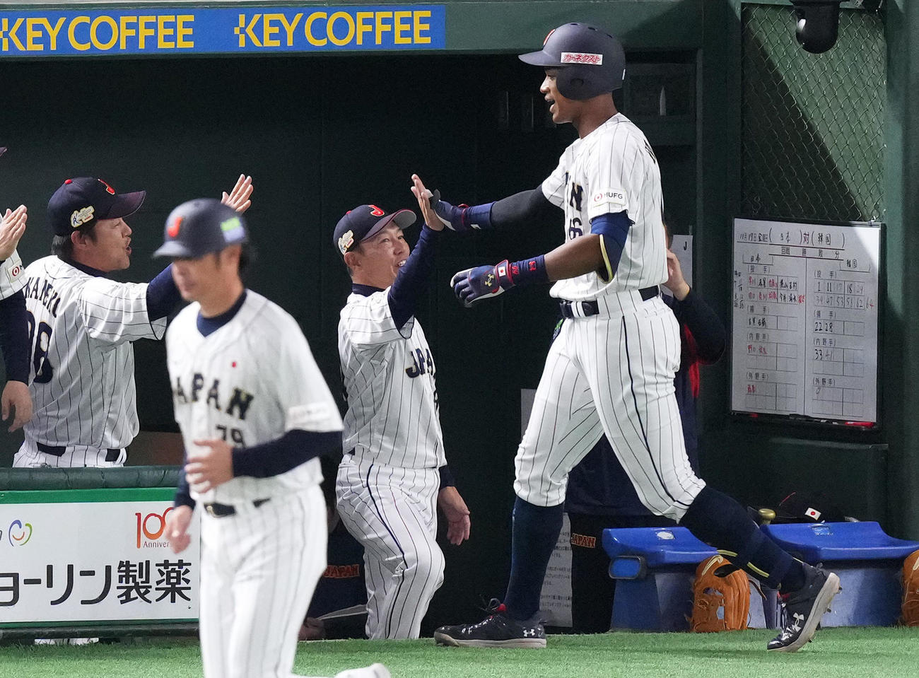 日本対韓国　4回裏日本無死、中越えにソロ本塁打を放ち、井端監督（中央）に迎えられる万波（右）（撮影・菅敏）