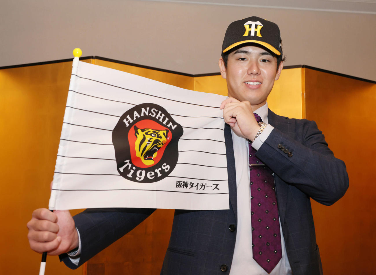 阪神との仮契約を済ませ、会見後にポーズを決めるドラフト5位、JR西日本の石黒選手（撮影・加藤孝規）