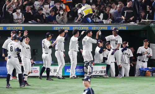 日本対韓国 6回裏日本1死三塁、佐藤輝(左端)の同点の中犠飛で三塁から生還し、ナインに迎えられる万波(右から3人目)(撮影・菅敏)
