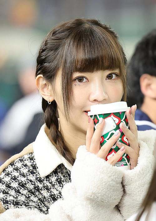 コーヒーカップを手にスタンドで笑顔を見せる台湾のチア（撮影・足立雅史）