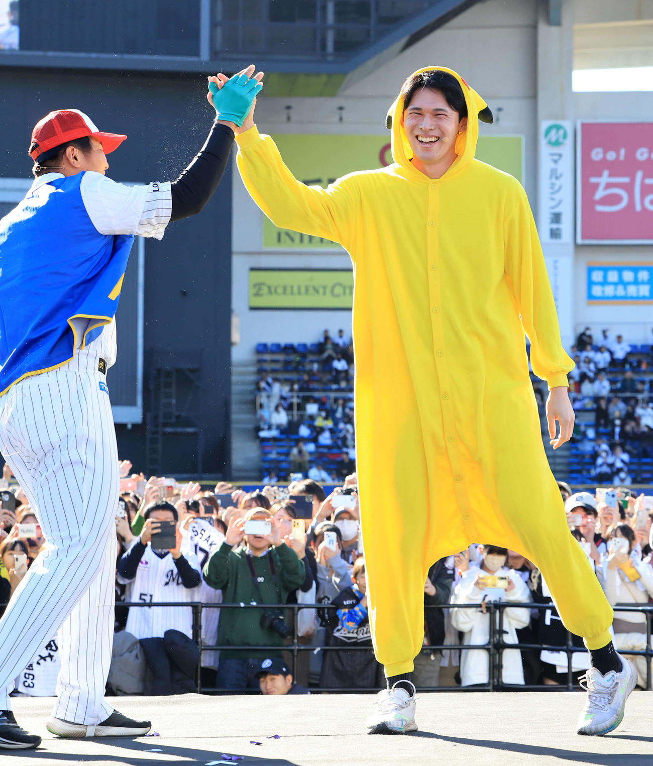 ロッテファンフェスタのアチアチカップル対決変装部門でピカチュウに扮（ふん）した佐々木朗（右）は、サトシに扮（ふん）した松川と笑顔でハイタッチ（撮影・浅見桂子）