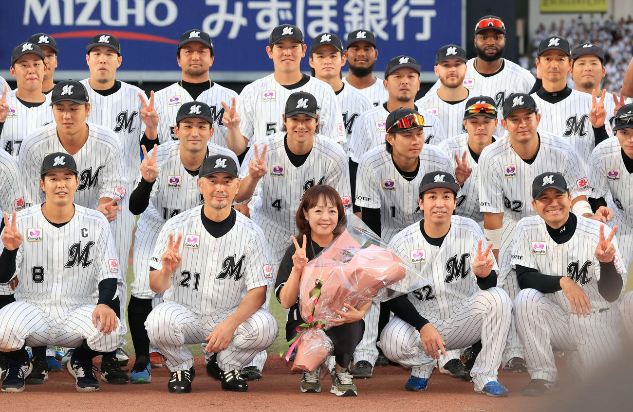 10月7日、ロッテ吉井理人監督（前列左から２人目）、選手に囲まれ、記念撮影をする谷保恵美さん