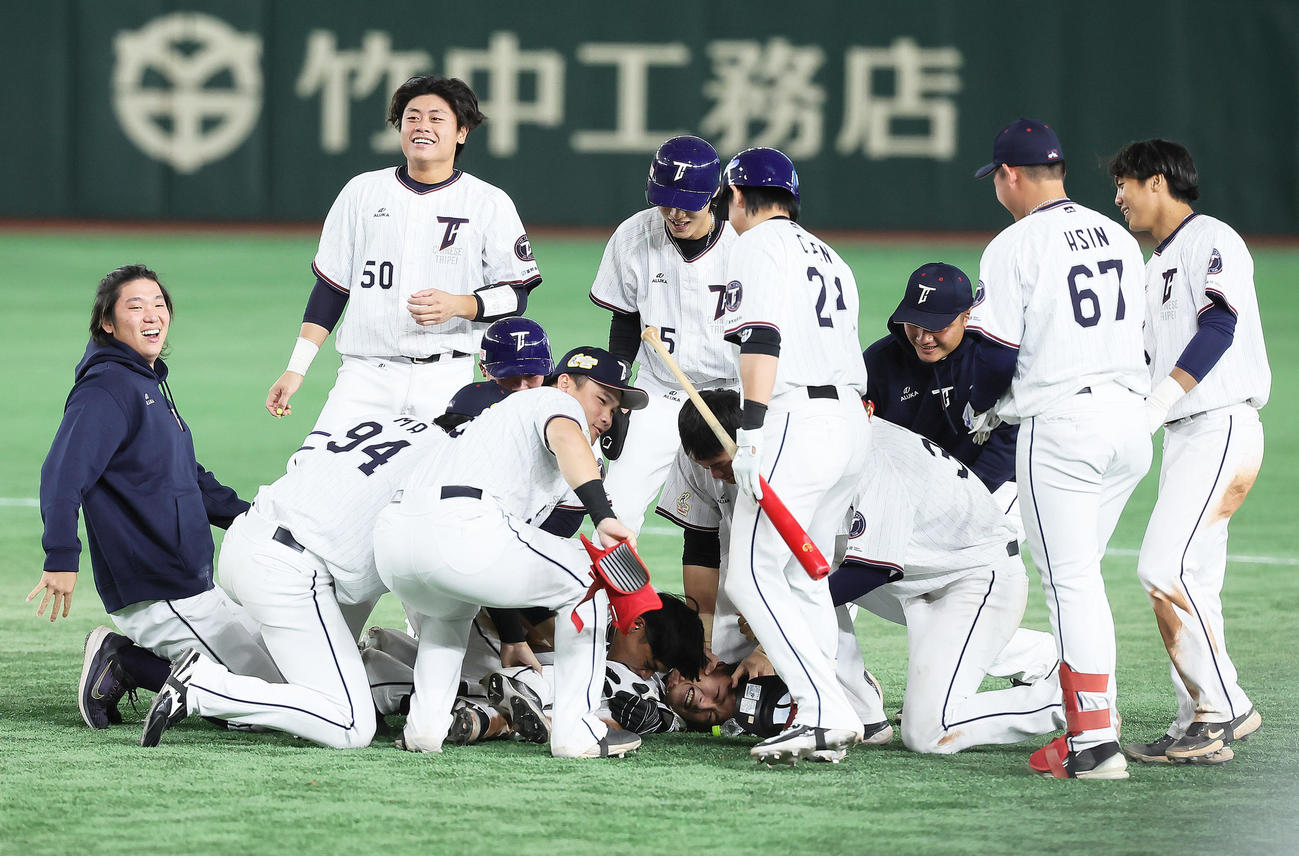 台湾対オーストラリア　9回裏台湾1死一、三塁、郭天信（中央下）はサヨナラ打を放ち手洗い祝福を受ける（撮影・足立雅史）