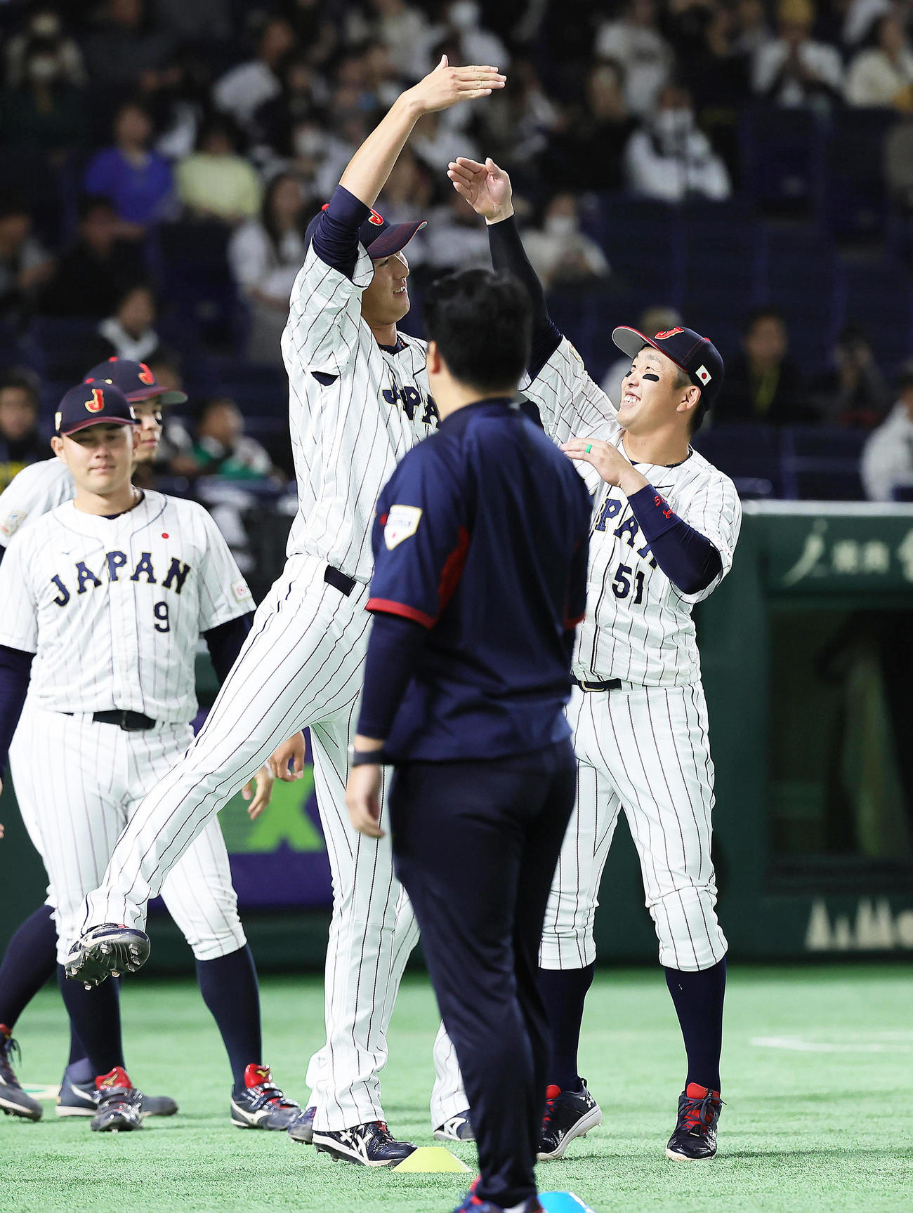 練習中、じゃれ合う秋広（左）と小園（撮影・足立雅史）