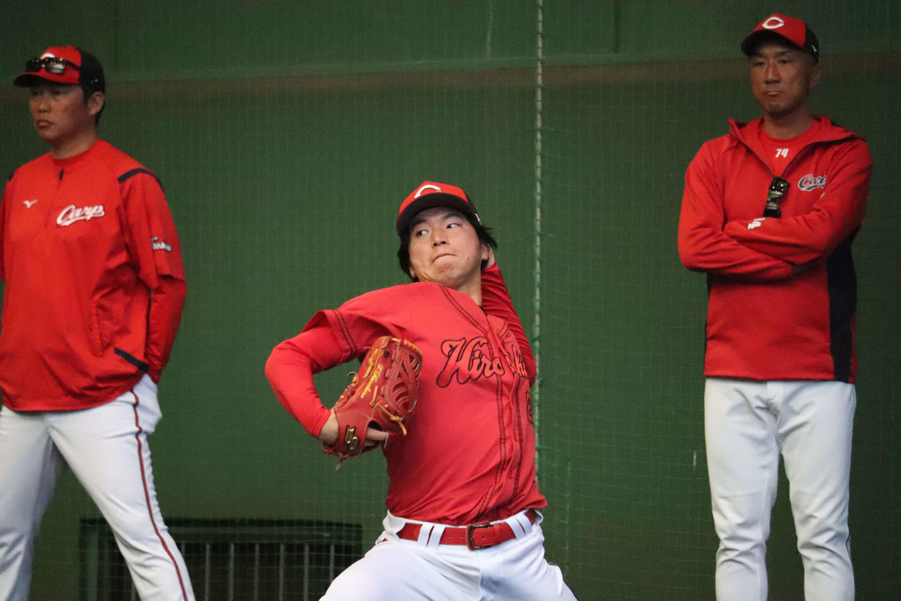 広島新井貴浩監督（左）の前でブルペン投球する黒原拓未投手（中央）（撮影・前原淳）