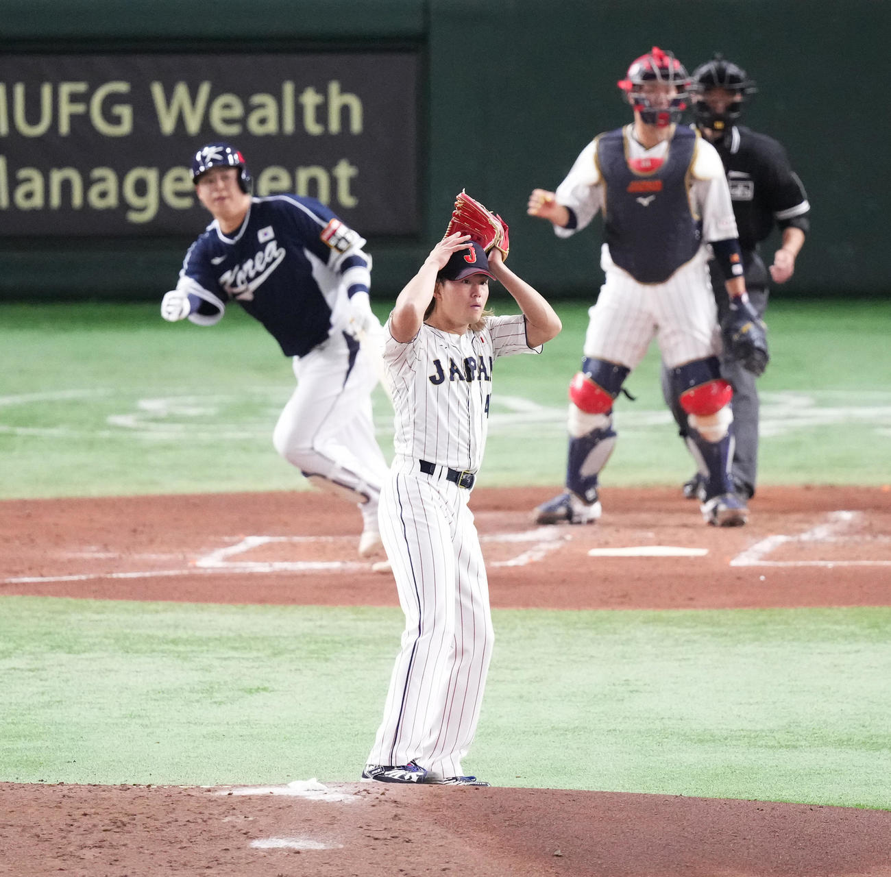 日本対韓国　3回表韓国1死一、二塁、盧（奥）に先制の2点適時二塁打を打たれ、頭を抱える今井（撮影・菅敏）