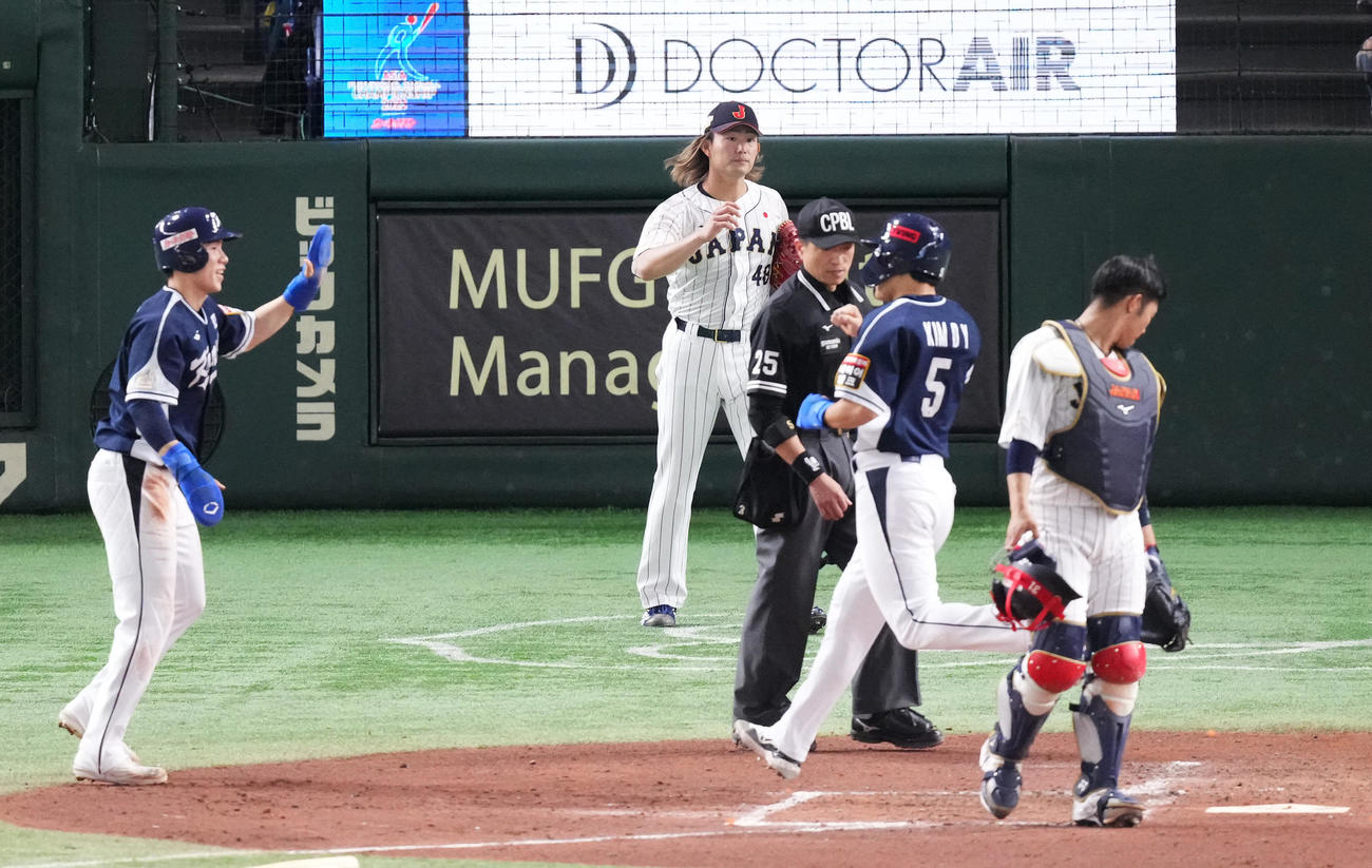 日本対韓国　3回表韓国1死一、二塁、盧施〓に先制の2点適時二塁打を打たれ、生還する走者を前に浮かない表情を見せる今井（奥）（撮影・菅敏）