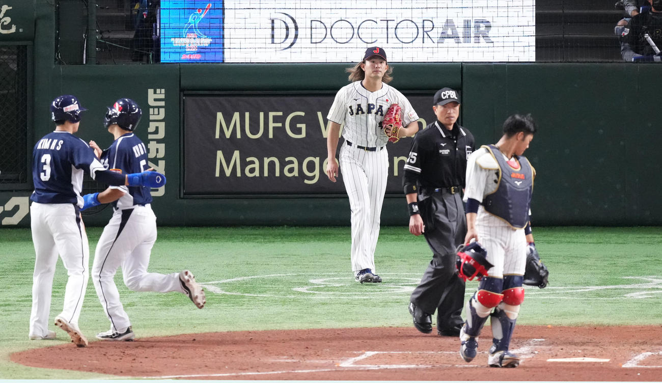 日本対韓国　3回表韓国1死一、二塁、盧施〓に先制の2点適時二塁打を打たれ、生還する走者を前に浮かない表情を見せる今井（奥）（撮影・菅敏）