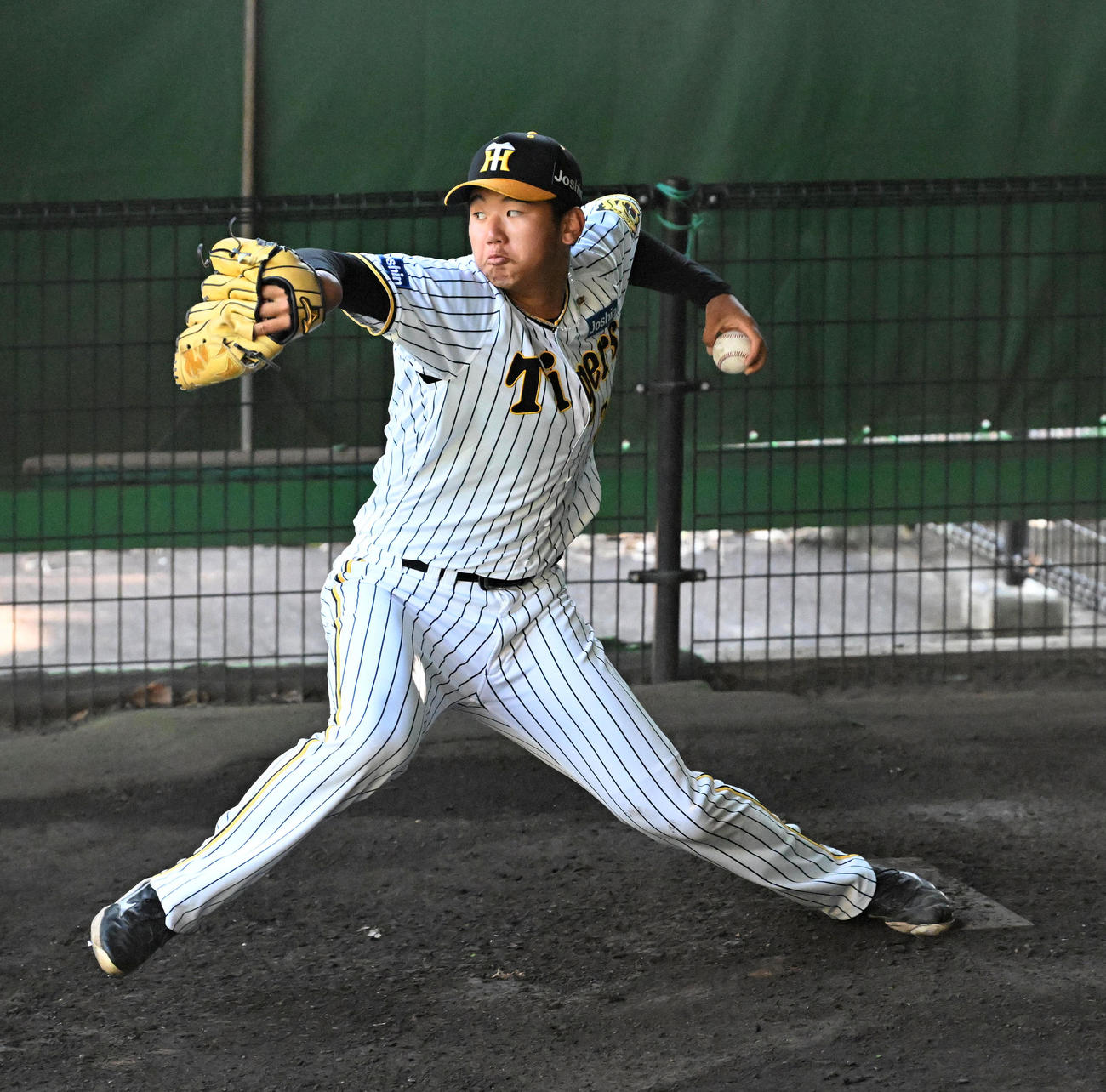 ブルペンで投球練習を行う門別（撮影・前岡正明）