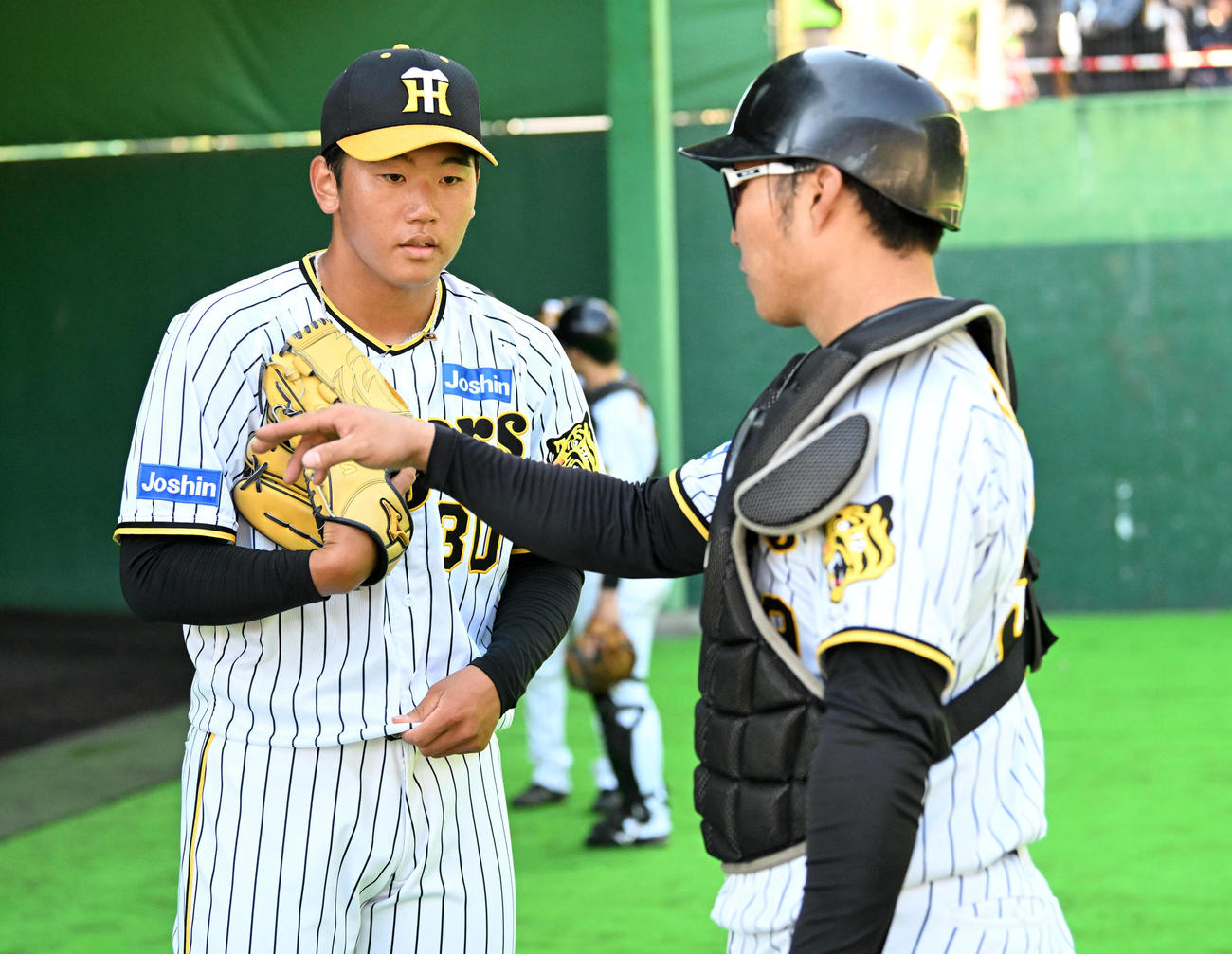 ブルペンで投球練習を終え藤田（右）と話す門別（撮影・前岡正明）