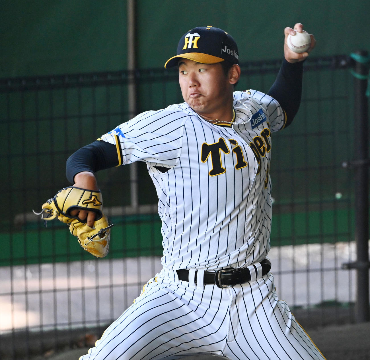ブルペンで投球練習を行う門別（撮影・前岡正明）