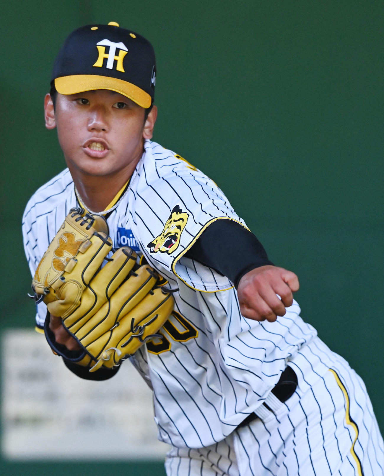 ブルペンで投球練習を行う門別（撮影・前岡正明）