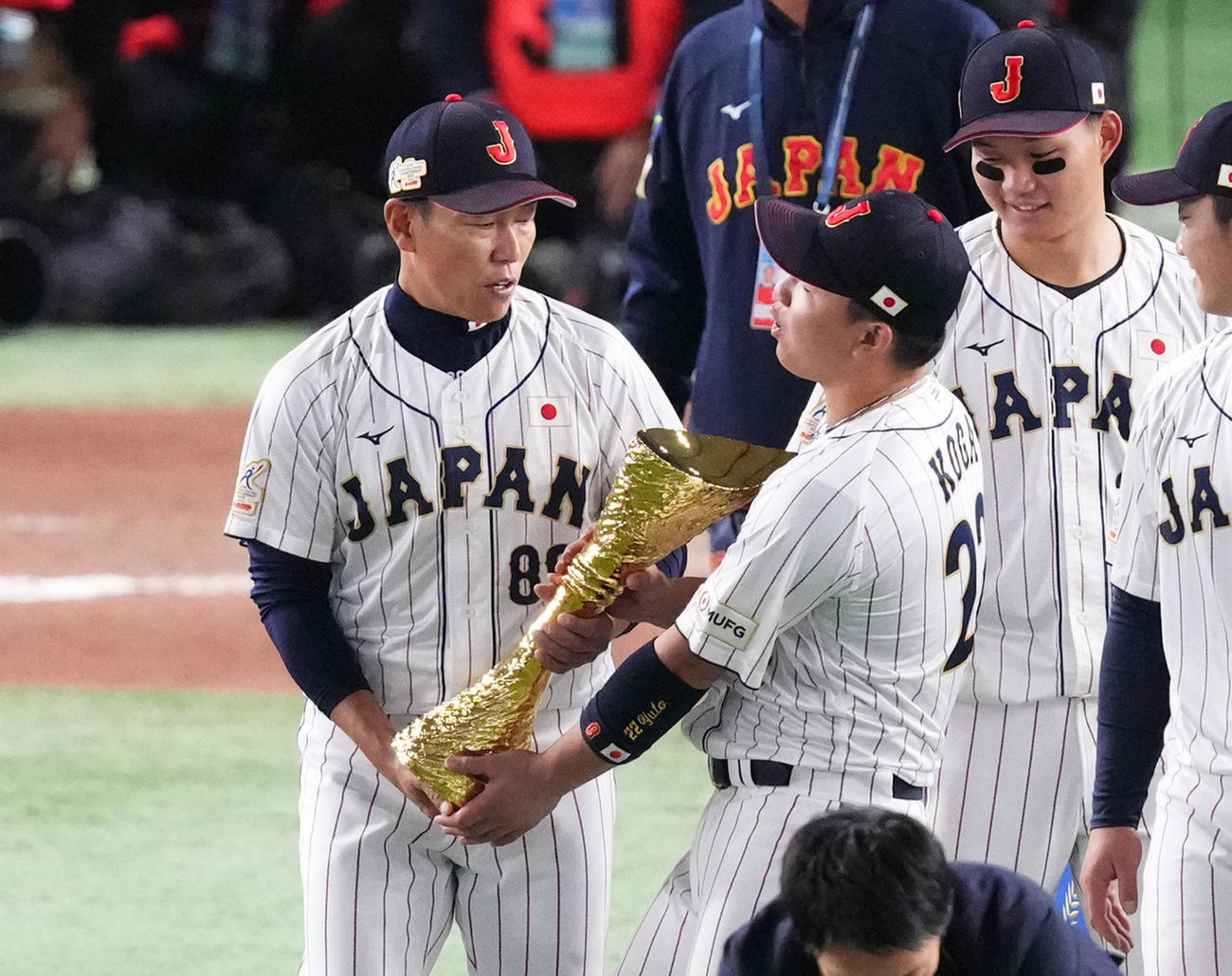 優勝トロフィーを井端監督（左）から受け取る古賀（撮影・菅敏）
