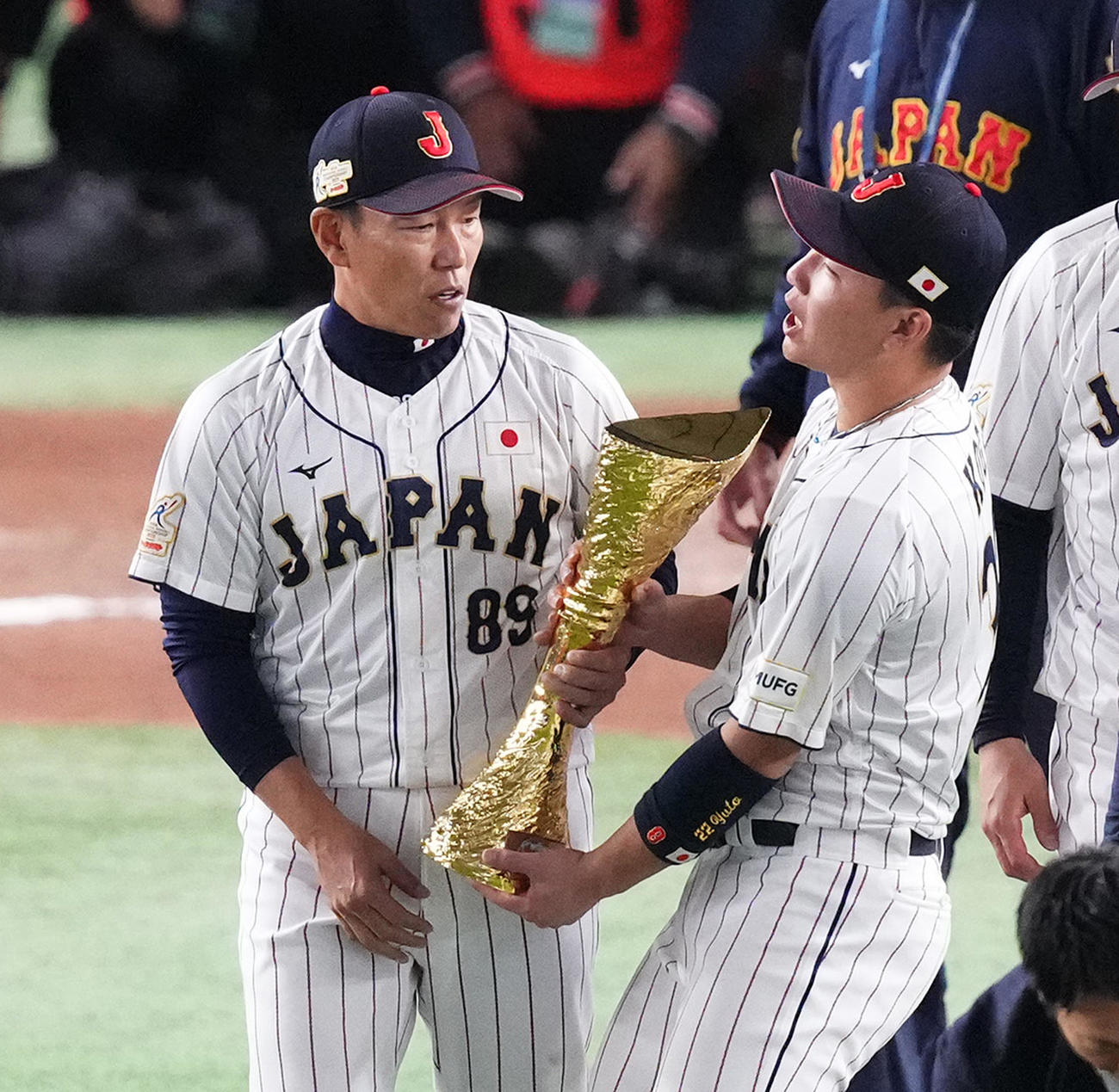 優勝トロフィーを井端監督（左）から受け取る古賀（撮影・菅敏）